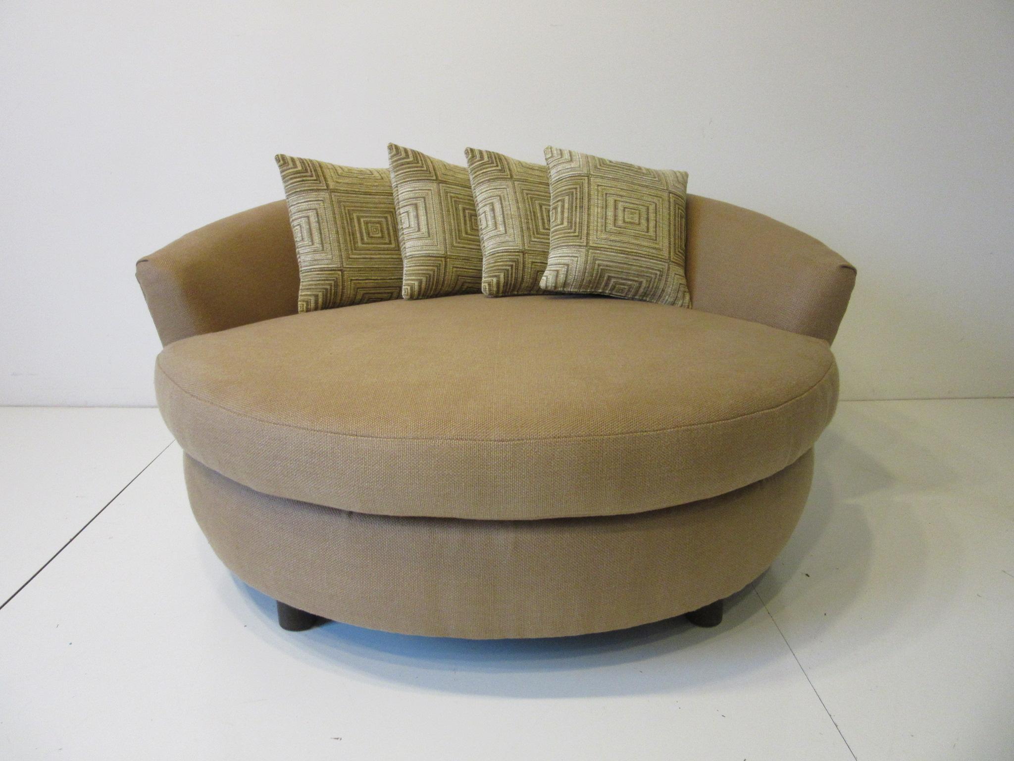 A round upholstered lounger / sofa chair with curved backrest all covered in soft and comfortable Italian linen with four woven fabric throw pillows. Sitting on larger rounded wooden legs making this piece very sturdy and useful for your living