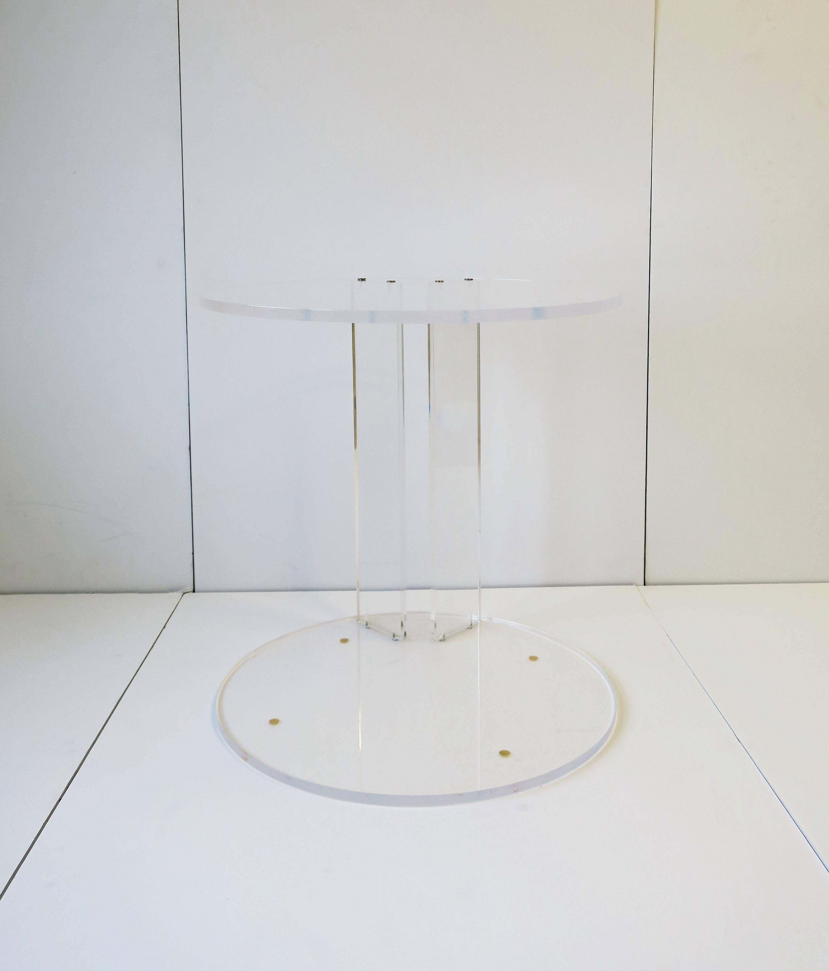 A Post-Modern [Postmodern] or Modern style Lucite/acrylic round side table or end table. Lucite measures 1/2 inch thick. Table can work as a side table or end table. Base area can be left bare or can be used to hold/display books, a plant, etc., as