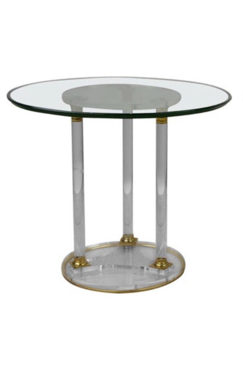Stunning round side table made of Lucite and brass with a thick glass tabletop. 
These circular drink table - coffee table or cocktail table dates from the 1970s.
It has nice brass details and is still in very beautiful condition.
A modern design