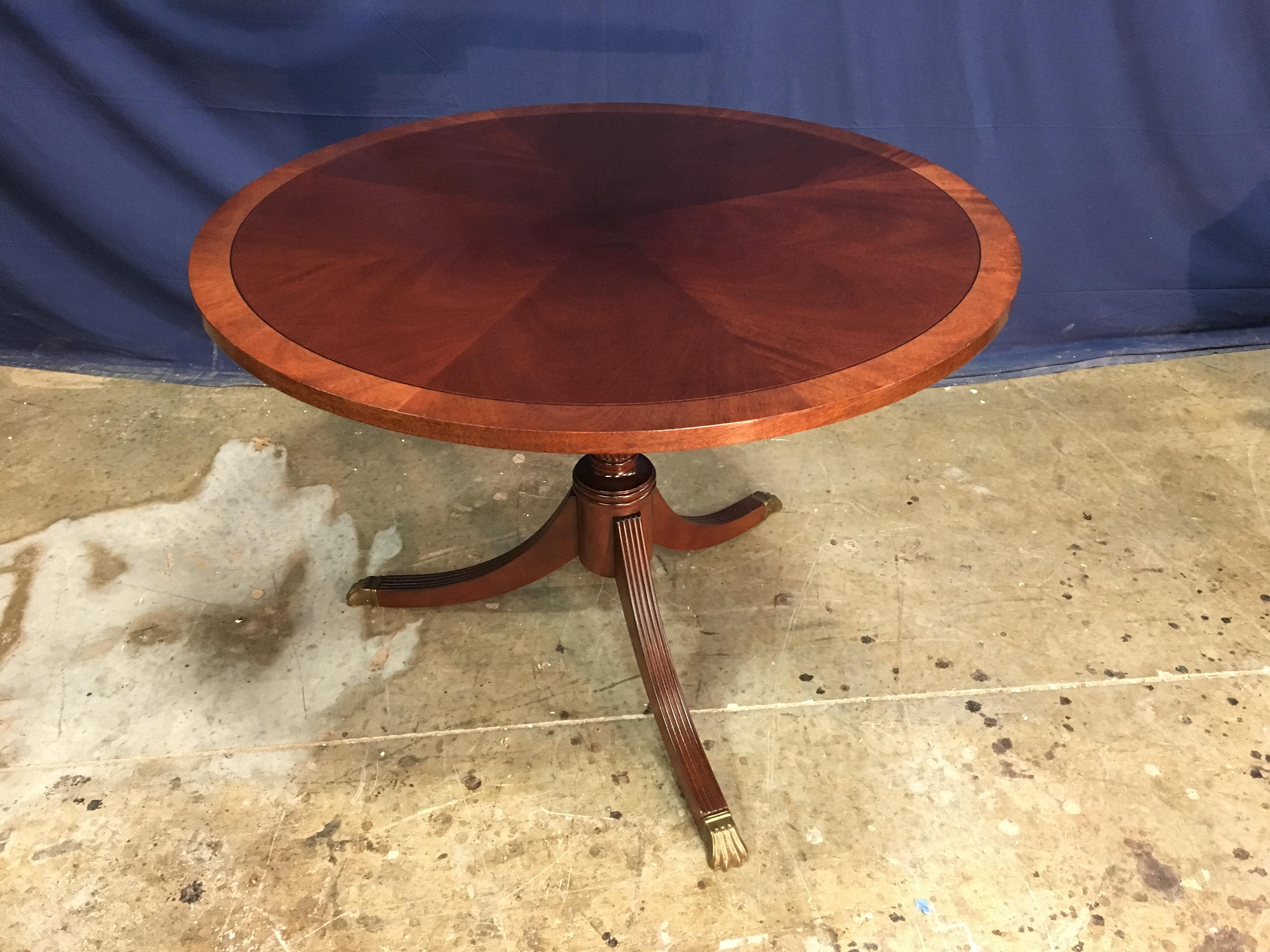 Cette table ronde d'accent ou de foyer en acajou traditionnel est fabriquée sur commande dans l'atelier de Leighton Hall. Il présente un champ d'acajou cathédrale à coupe radiale avec une bordure contrastée en acajou. Il a une finition
