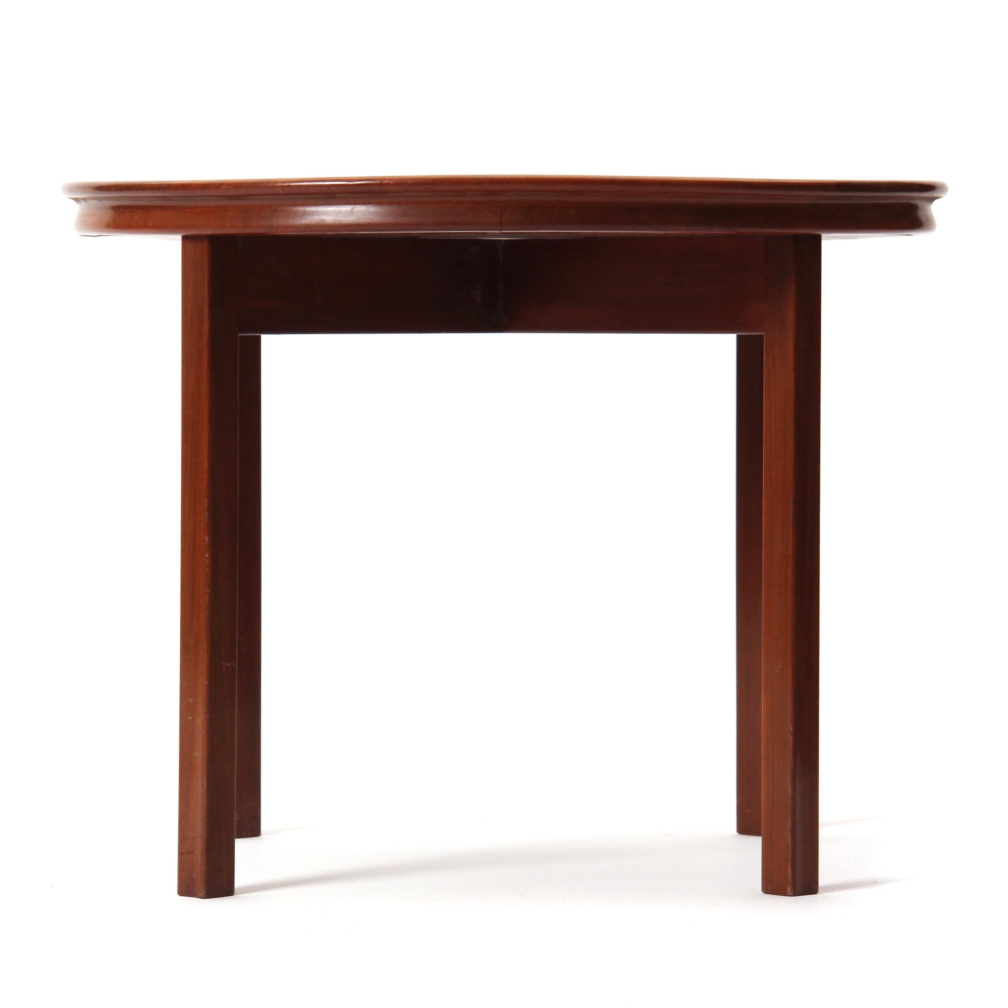 A round mahogany end table / side table attributed to Ole Wanscher featuring a flared rim and straight, concave-faced legs. Made in Denmark, circa 1940s.