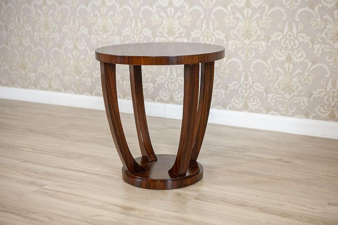 Round Mahogany Side Table From the Late 20th Century Stylized as Art Deco

We present you a round side table from the 2nd half of the 20th century stylized as Art Deco and made of mahogany veneer. The top is round and placed on four arch-like