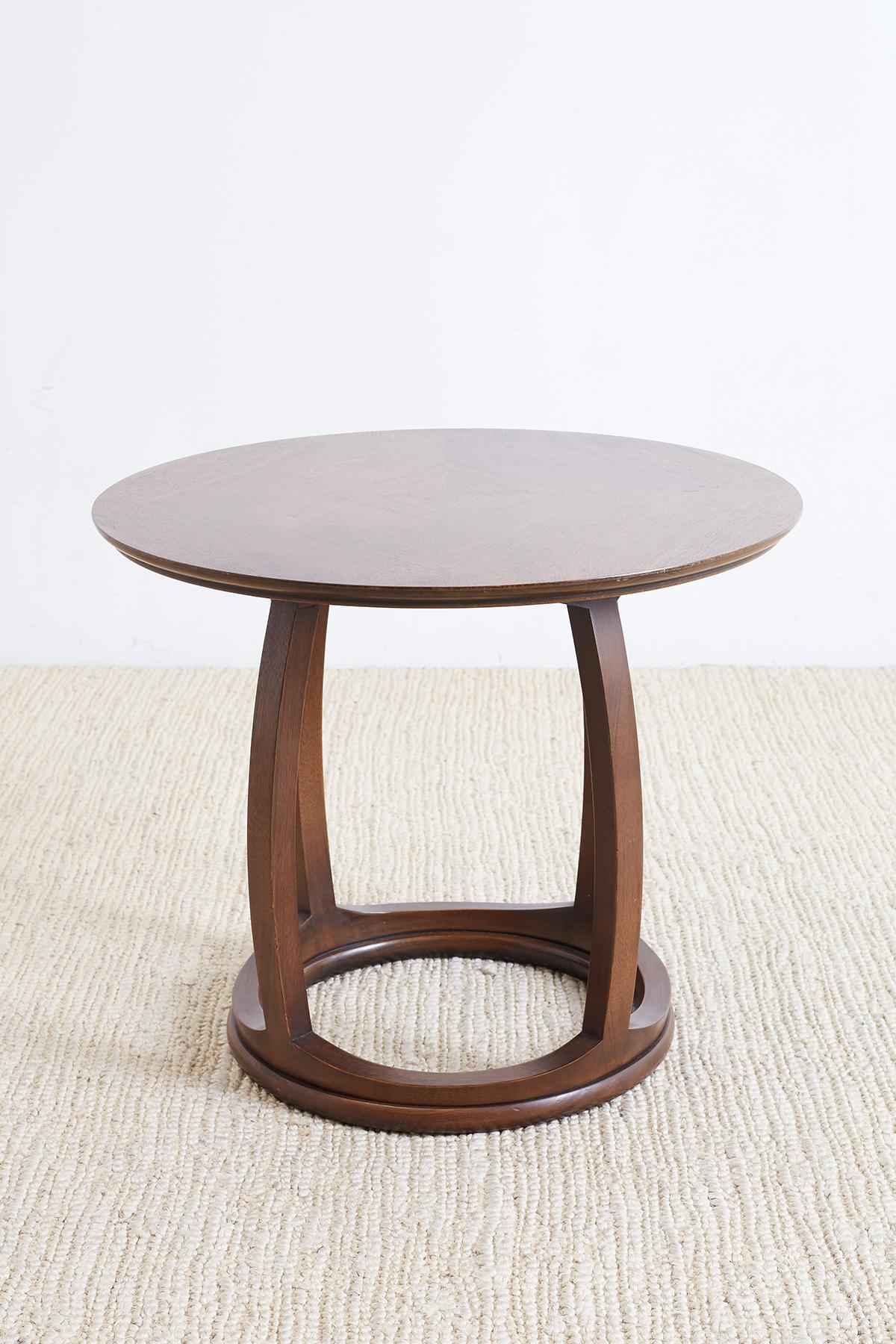 Handsome mahogany round side table, drink table or tabouret having a round top and a drum shaped base. The table has a beautiful match veneer of mahogany laid in a geometric form. Supported by curved legs with a rind shaped stretcher on the bottom.
