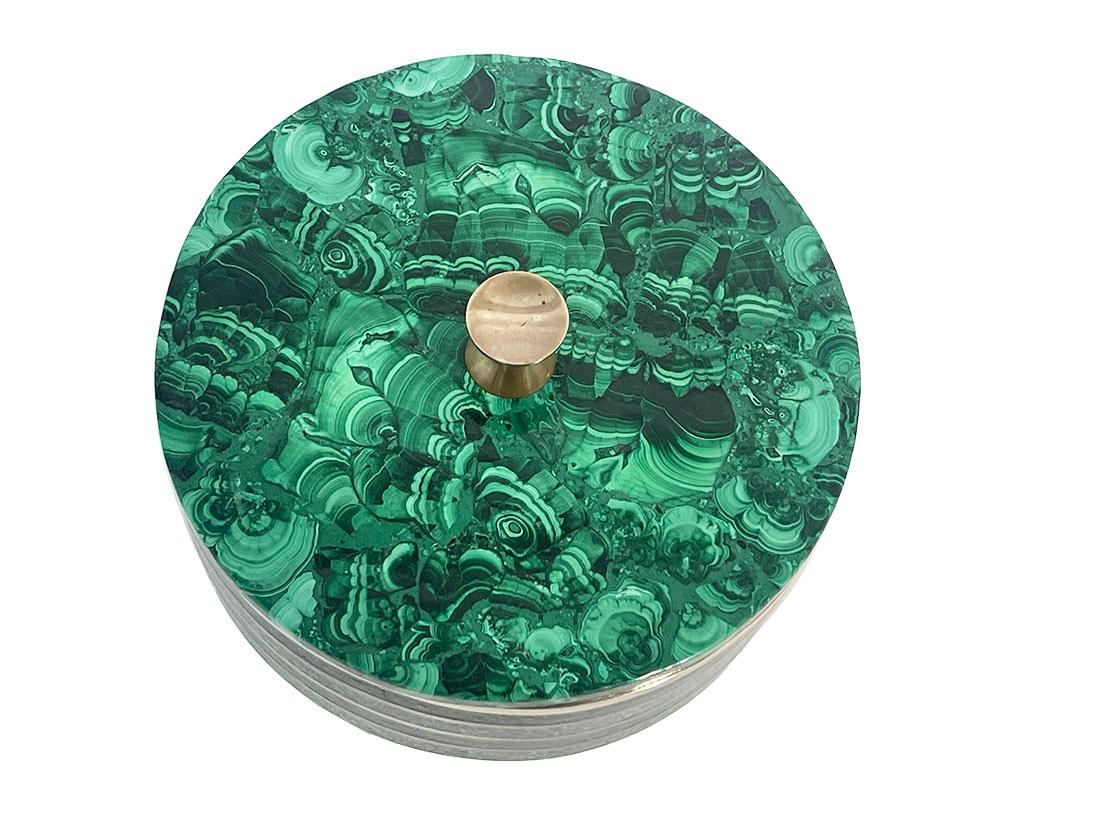 Boîte ronde en malachite avec laiton

Boîte en malachite du milieu du 20e siècle. Anneau de cuivre incrusté de malachite à l'extérieur.
La base et le couvercle sont en malachite et reposent sur trois pieds en marbre blanc. 
Le couvercle est muni