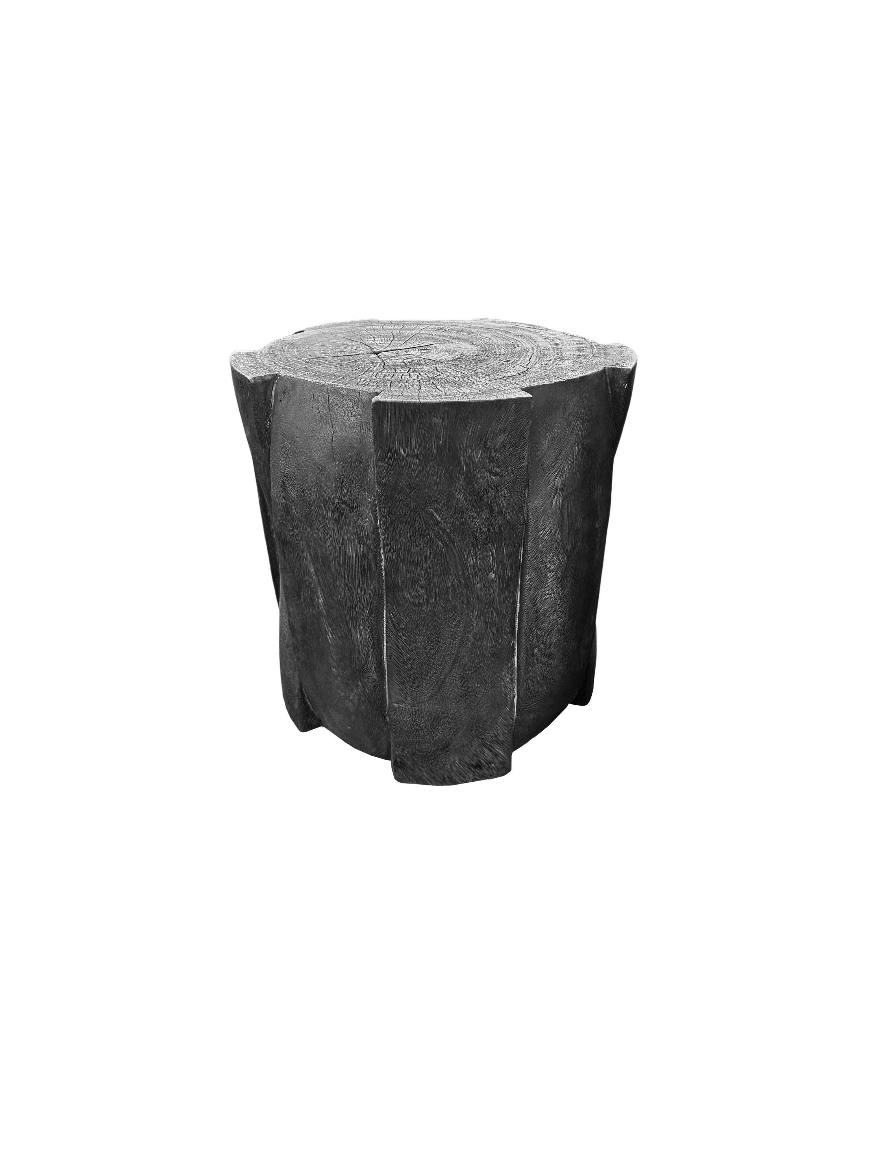 Une table d'appoint merveilleusement sculptée, fabriquée à partir d'un seul bloc de bois de manguier. Il présente de merveilleuses textures de bois. Cette table présente des détails sculptés qui enveloppent ses côtés, inspirés du bambou tressé. Pour