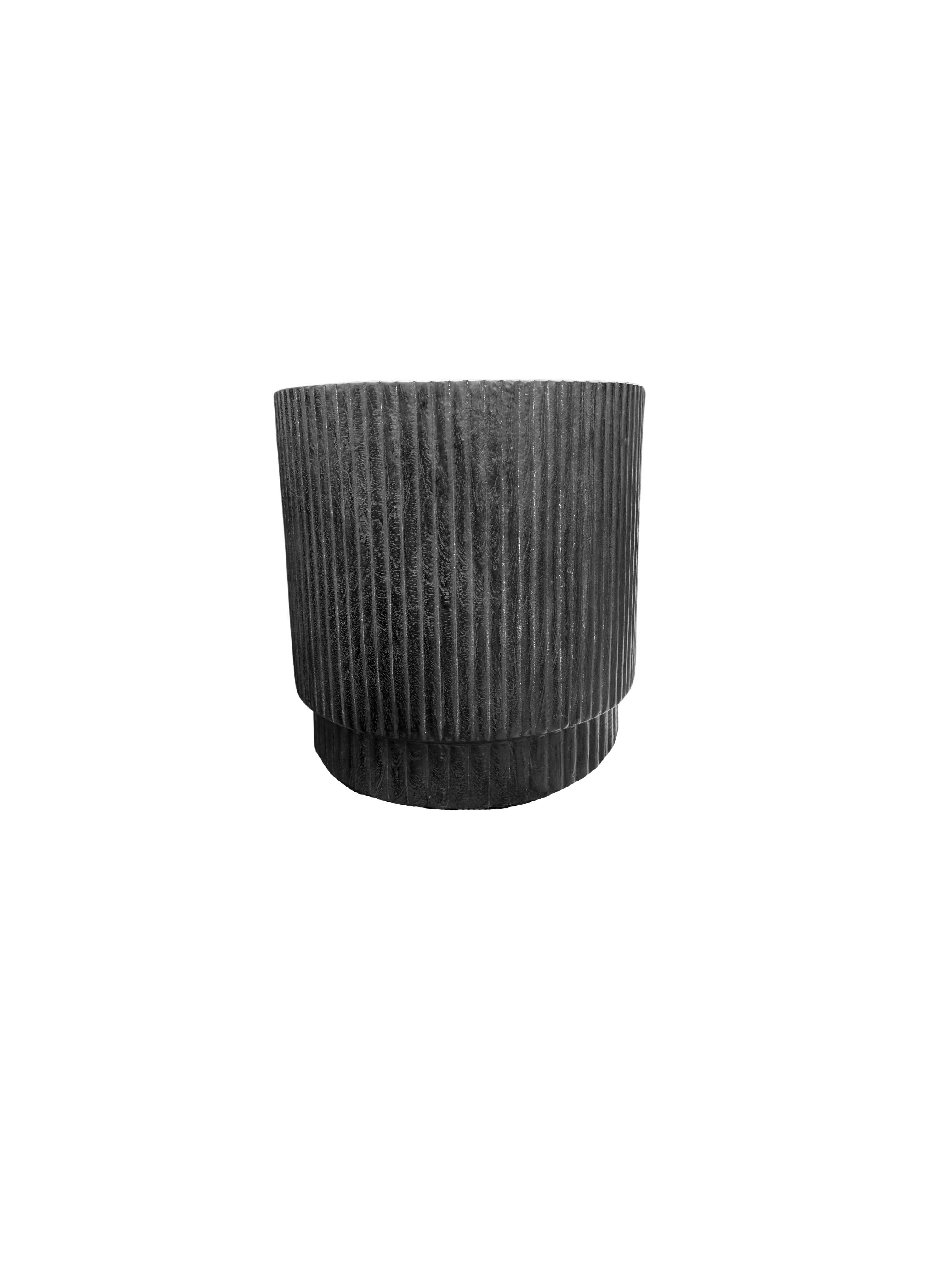 A wonderfully sculpted side table, crafted from a single block of mango wood. It features wonderful wood textures. This table features carved detailing that wraps around its sides. To achieve its black pigment the wood was burnt several times and