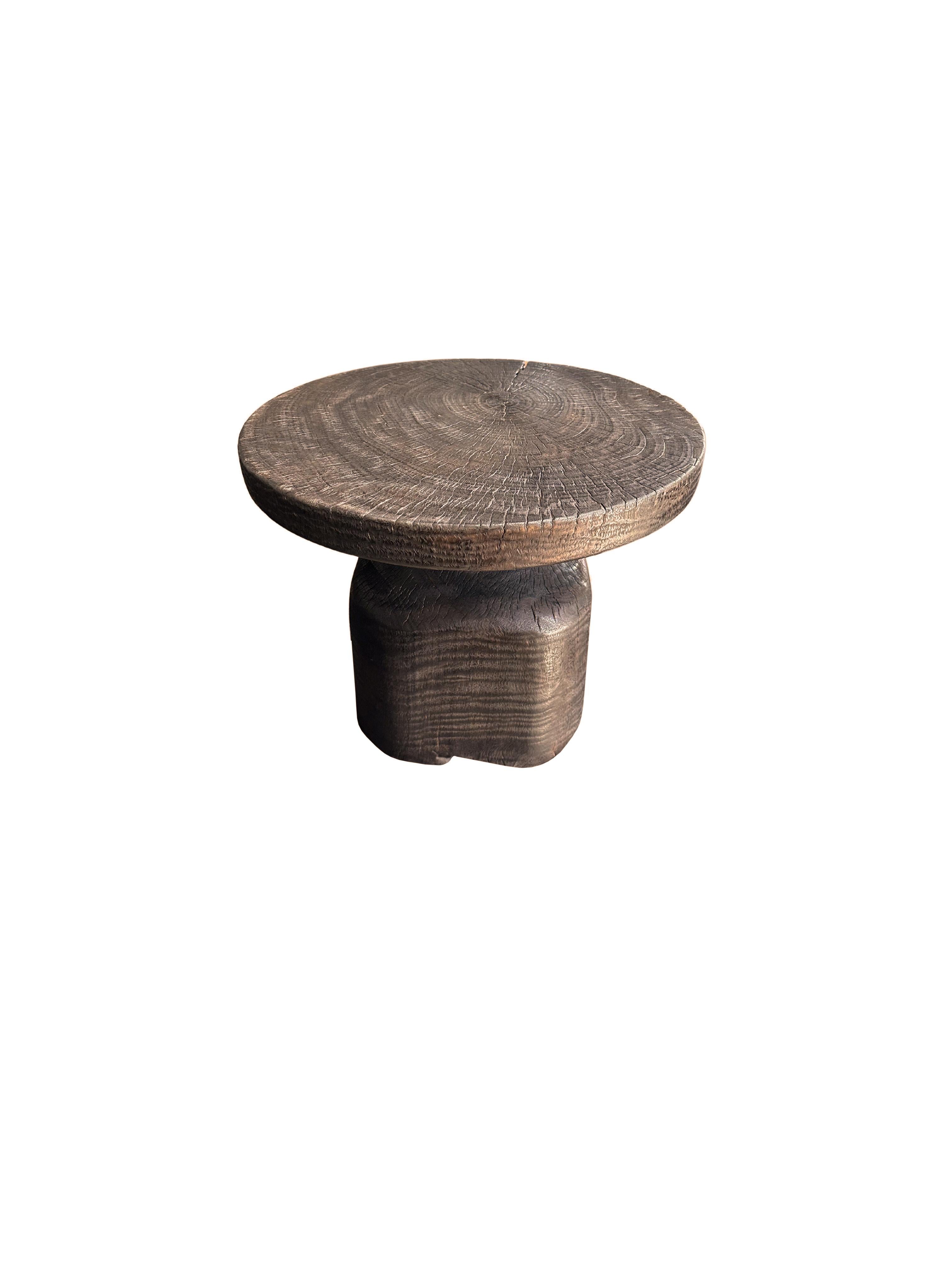 Ein wunderschön geformter Beistelltisch, der aus einem einzigen Block Mangoholz gefertigt ist. Es weist wunderbare Holztexturen auf. Um das dunkelbraune Finish zu erhalten, wurde das Holz mehrfach gebrannt und mit einem Klarlack überzogen. Dieser