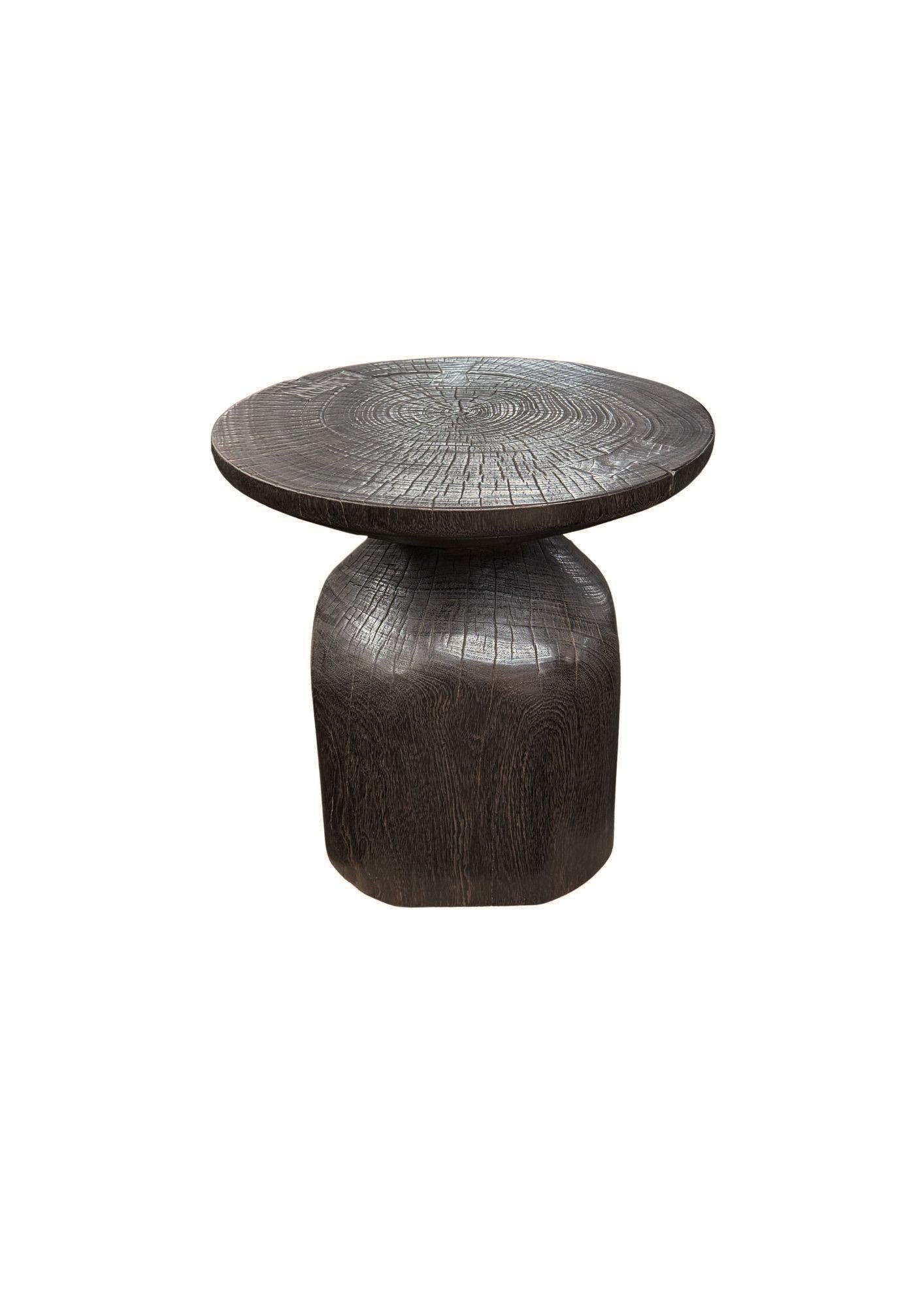 A wonderfully sculpted side table, crafted from a single block of mango wood. It features wonderful wood textures. To achieve its dark brown finish the wood was burnt several times and finished with a clear coat. This item was carved by skilled