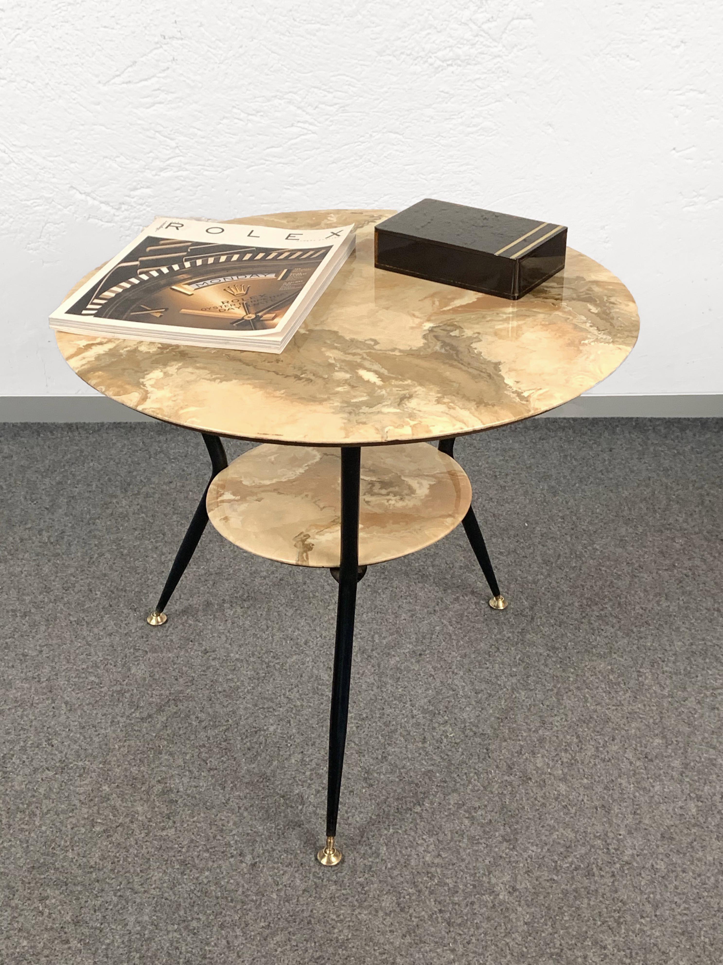 Wonderful midcentury marbled wooden base and lacquered black metal legs coffee table. It has two levels with varnished round bases, indicating a 1950s Italian production, 1950s, Italy.

It is a superb side or living room table with very elegant
