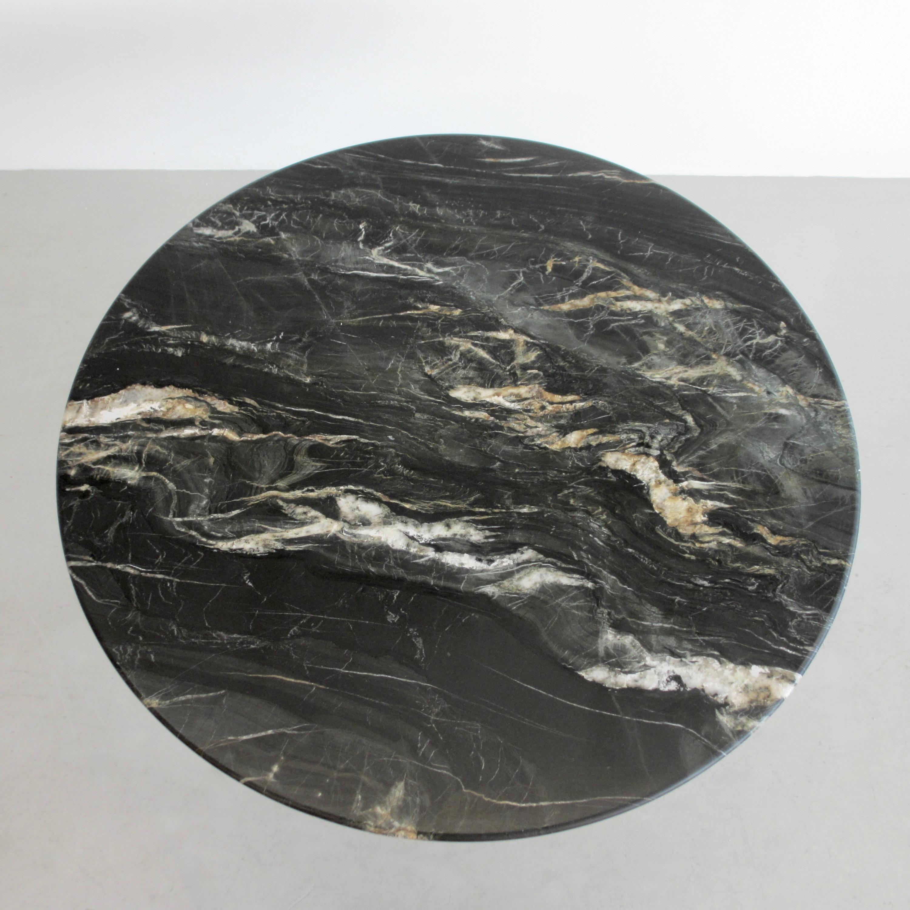 Table de salle à manger ronde en marbre (T69A) conçue par Osvaldo Borsani et Eugenio Gerli en 1963/64. Produit par TECNO.

Base en métal brossé, faces intérieures en émail noir mat. Plateau en marbre noir mat 'Belvedere' avec veines de différentes