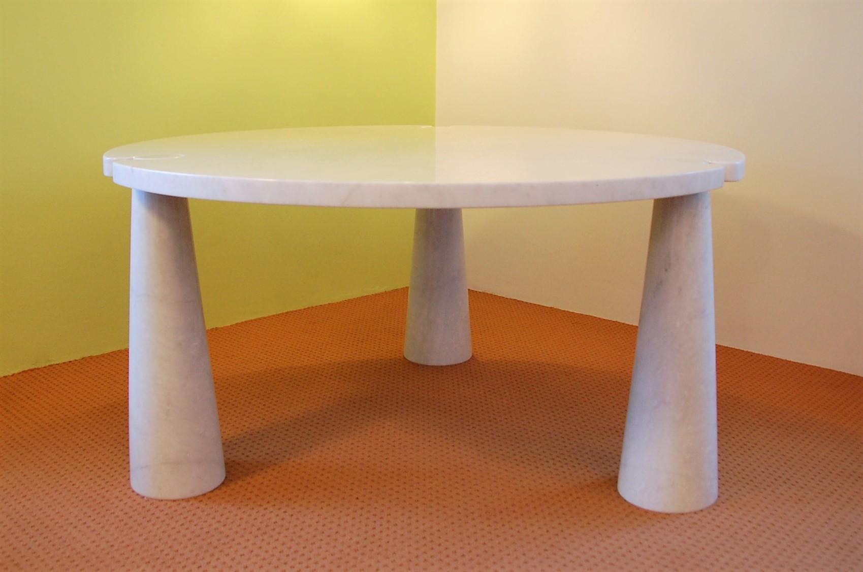 This beautiful and elegant round marble dining table was designed by Angelo Mangiarotti for Skipper in 1971. It is made solely of white Carrara marble. The top slides over the three cone shaped legs which makes it a very solid construction. This