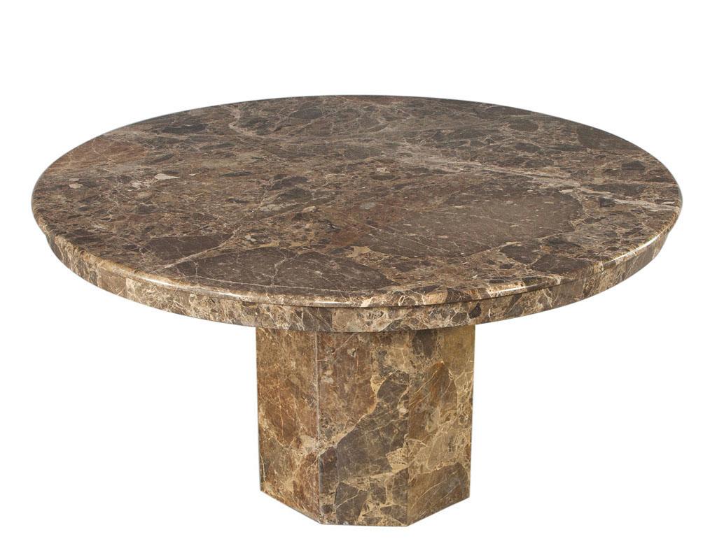 This exquisite vintage round marble dining table from Italy circa 1970s is a classic example of Italian craftsmanship and design. The table is made from all Italian marble and features an octagonal shaped pedestal and round top. The stunning earthy