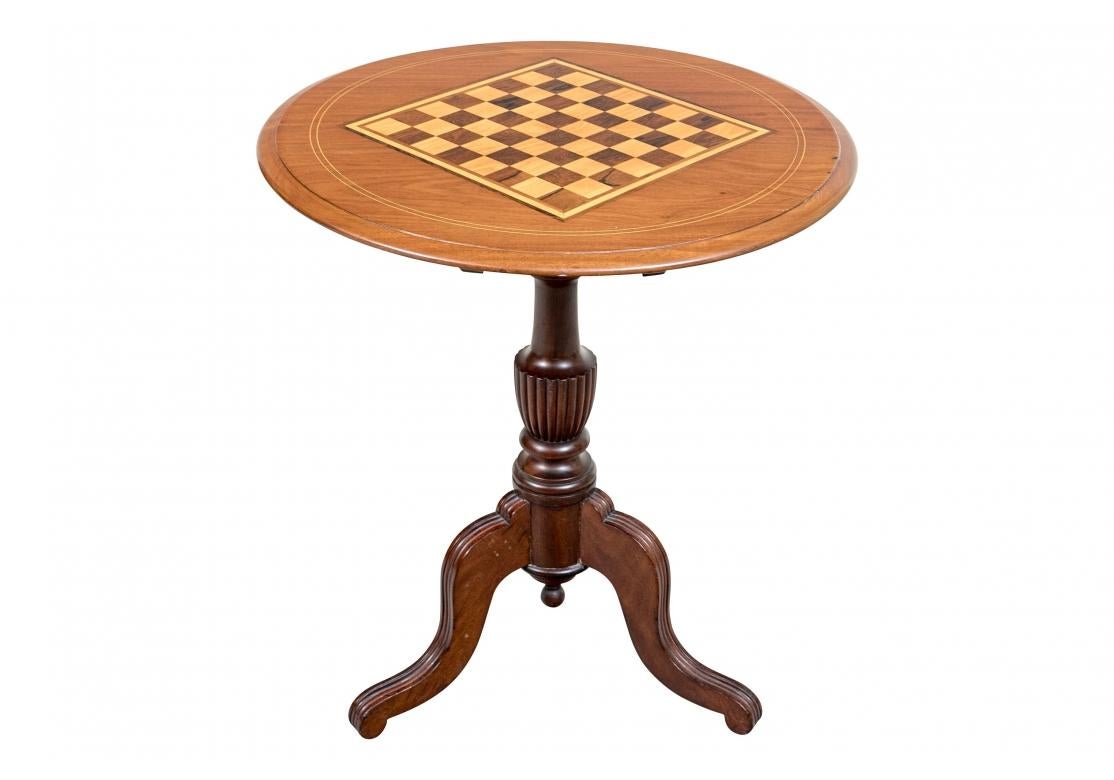 Round games table with marquetry design, string inlay, baluster from pedestal with tripod legs and terminating with a finial. The table tilts for easy storage when not in use.
Dimensions: 43