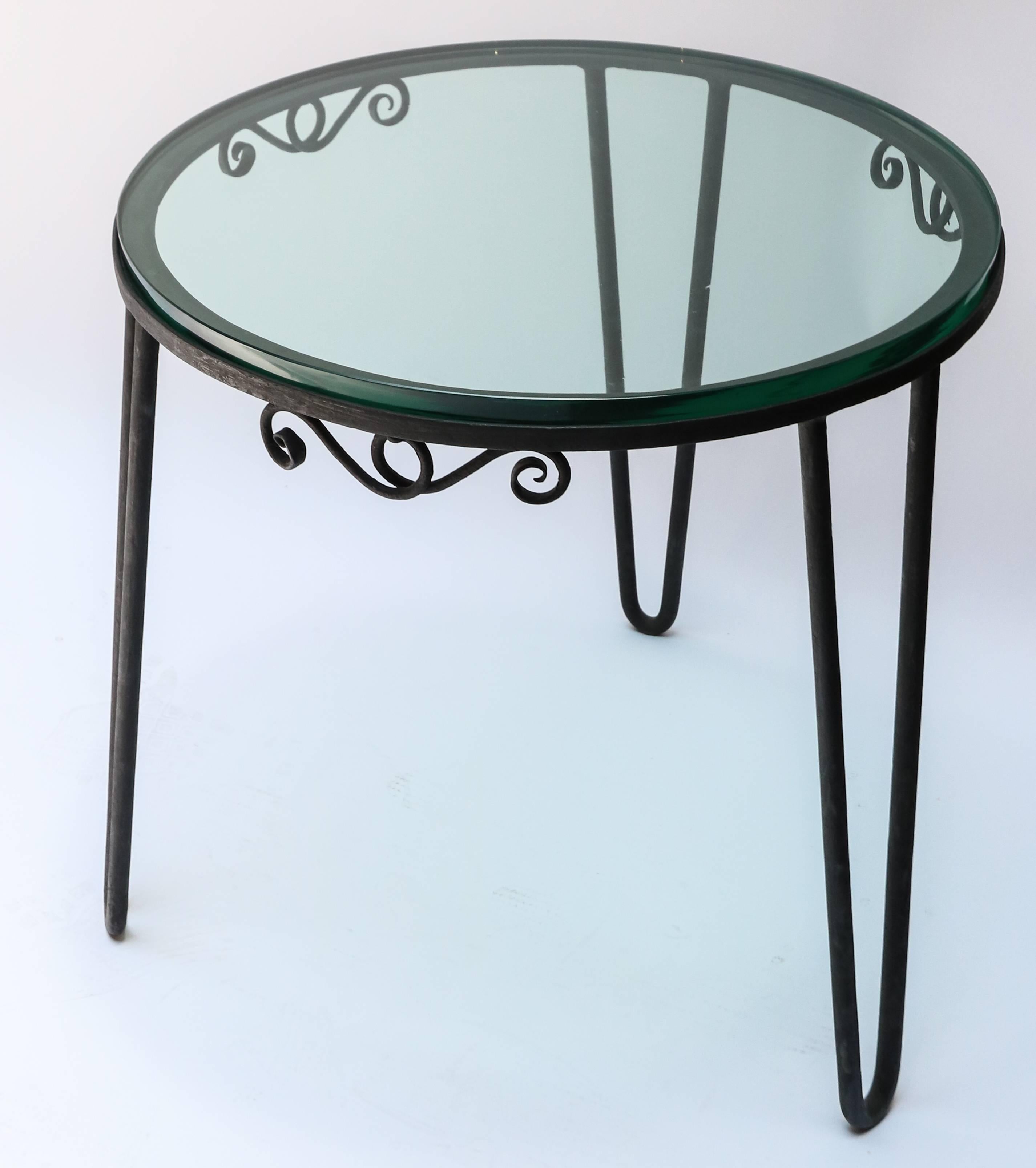 Round black metal Italian side table from the 1960s with thick glass top.