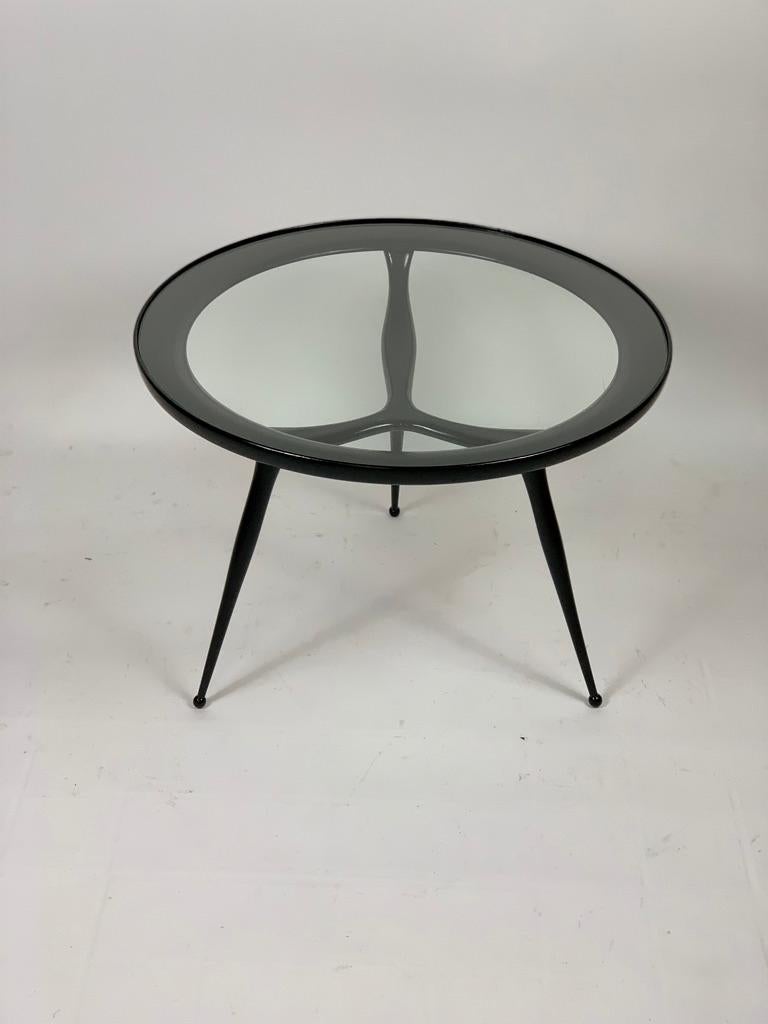 Italian side table or coffee table, three slender leggs support a round top with encased glass.
Mid-Century Modern 1950's.

 