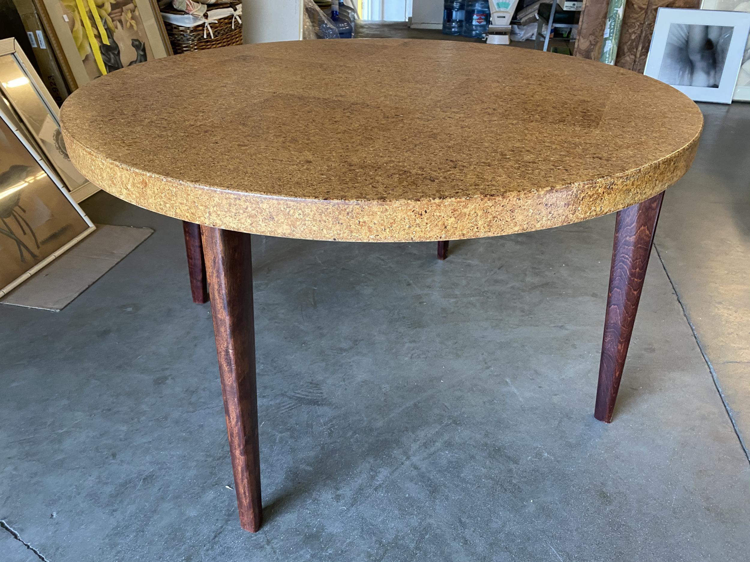 Rare Paul Frankl designed round cork top table for Johnson Furniture features a solid cork veneer top supported by tapered mahogany knife legs.