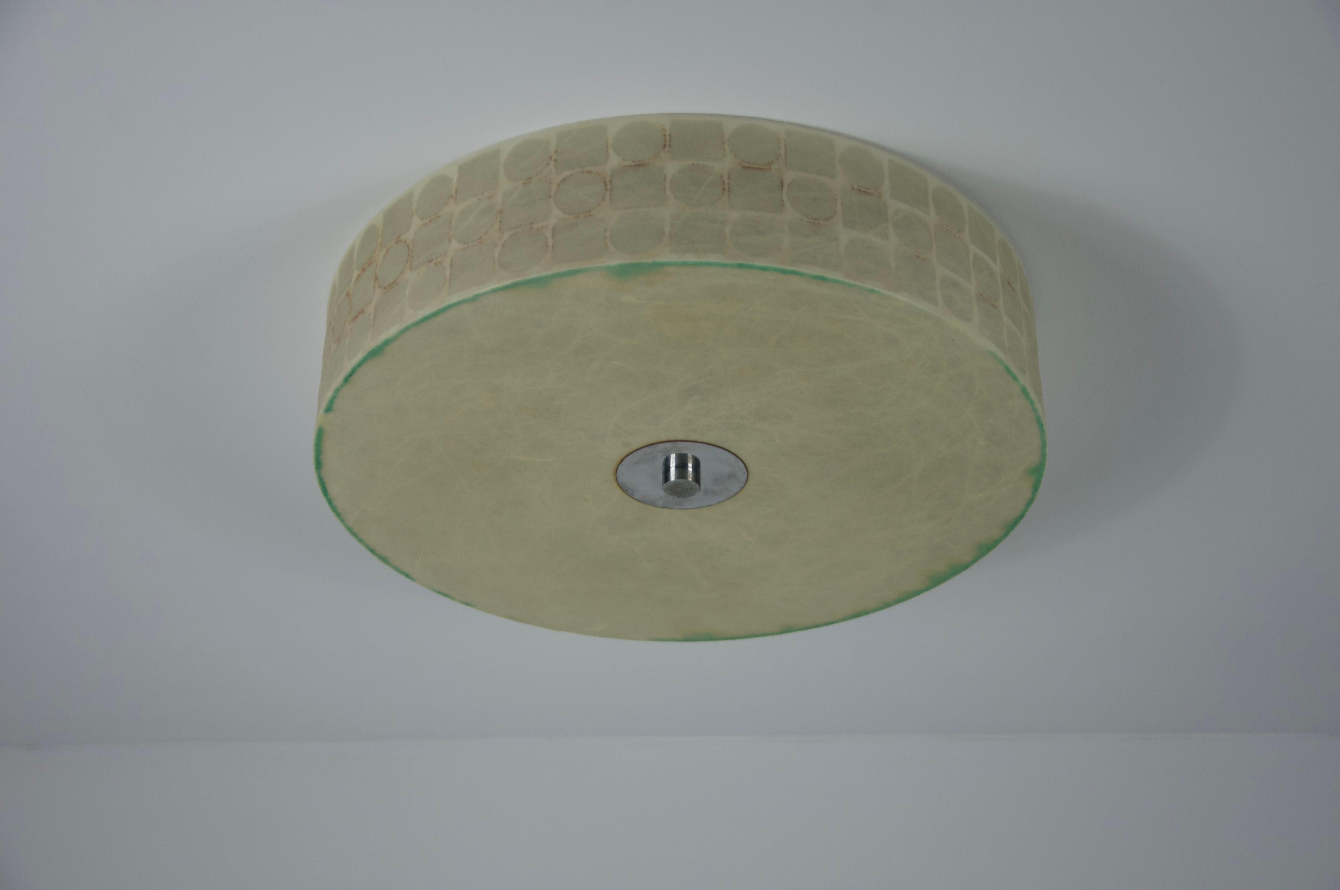 This elegant Cocoon ceiling lamp, crafted in Italy during the 1960s, embodies the sleek and timeless style reminiscent of renowned designer Achille Castiglioni. Its sophisticated round form gently tapers outward, creating a striking silhouette that