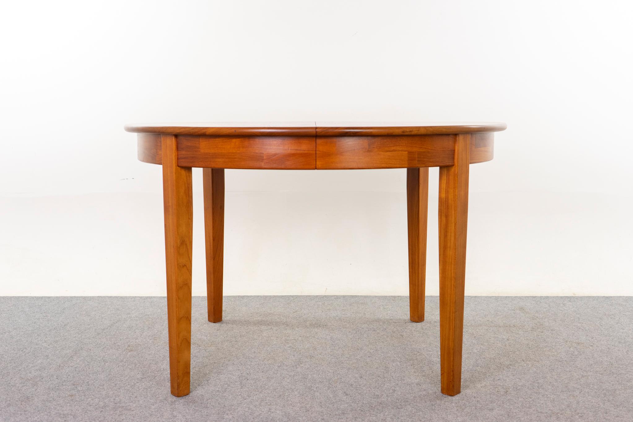 Teak Danish dining table, circa 1960s. Rare solid teak construction, very robust! Lovely social circle that seats 4 extends to accommodate 6 or 8, very comfortably! Nice rich tone teak and tapering legs. 

48