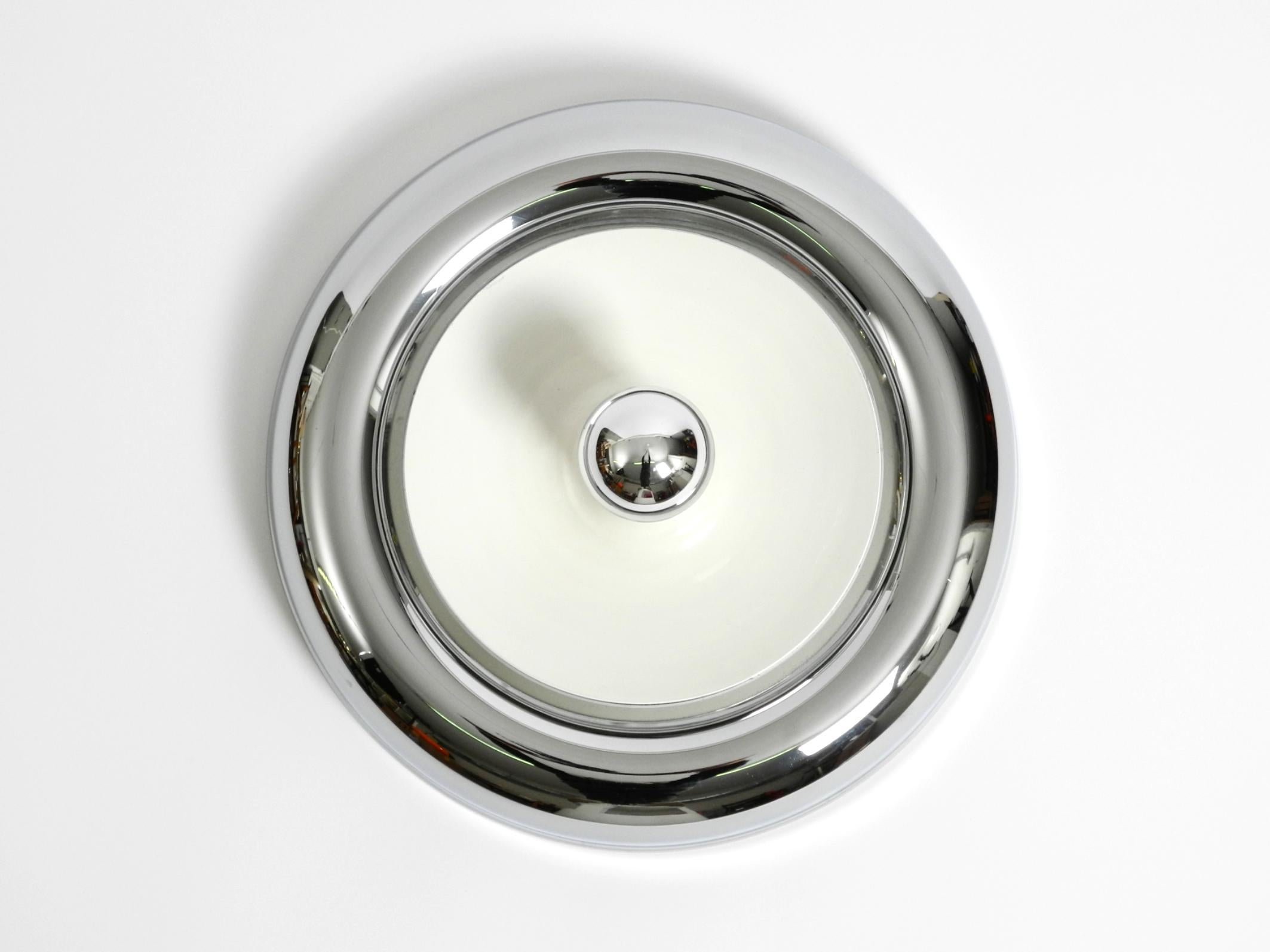 Lámpara de techo o de pared minimalista y original de la Era Espacial Mid Century Modern, de metal cromado. En el centro hay una pantalla metálica blanca extraíble.
Típico diseño de la Era Espacial de los años 60. Fabricado en Italia.
En muy buen