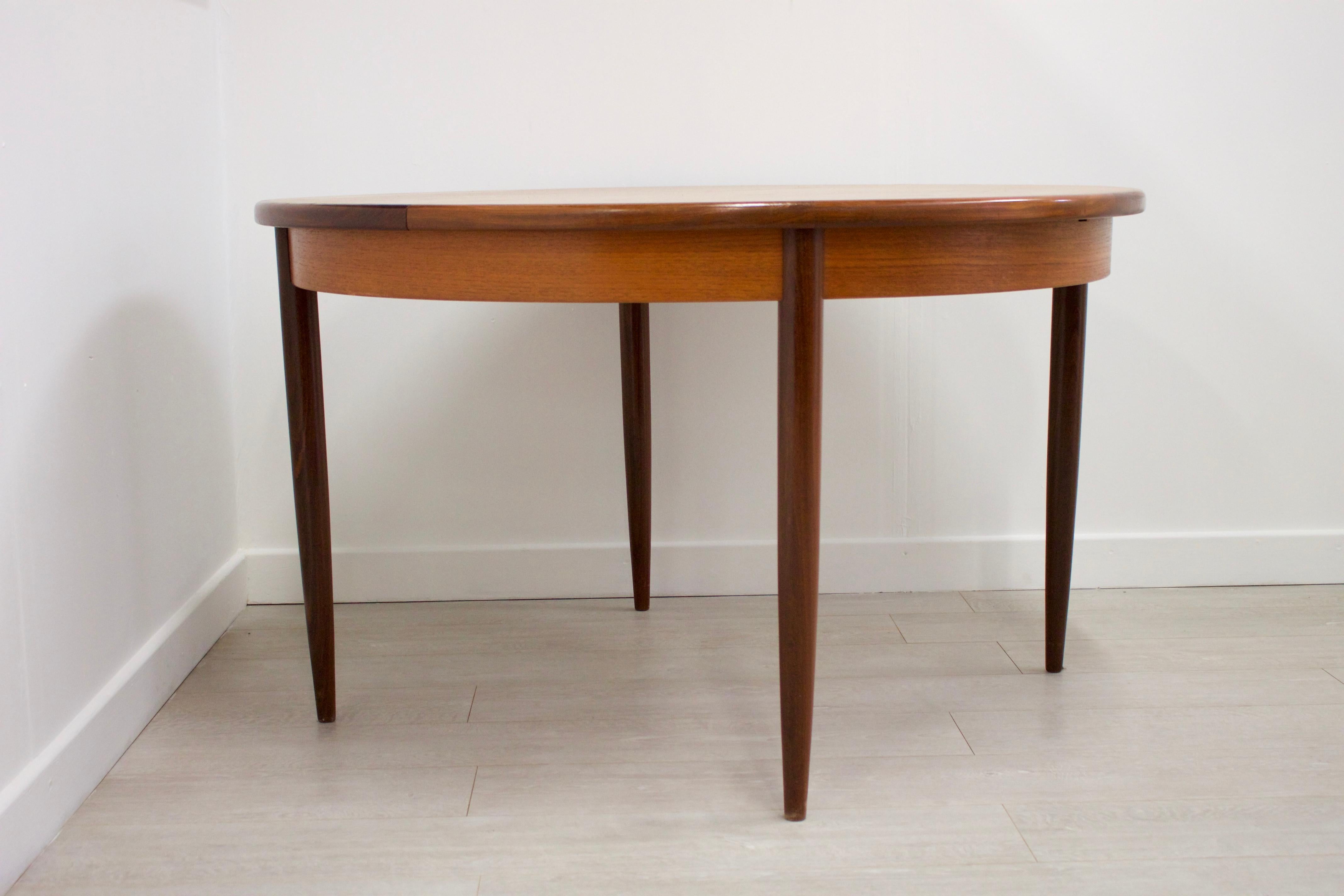 - Midcentury round extending dining table by G-Plan.
- Made from teak and teak veneer
- Extended width 157 cm.