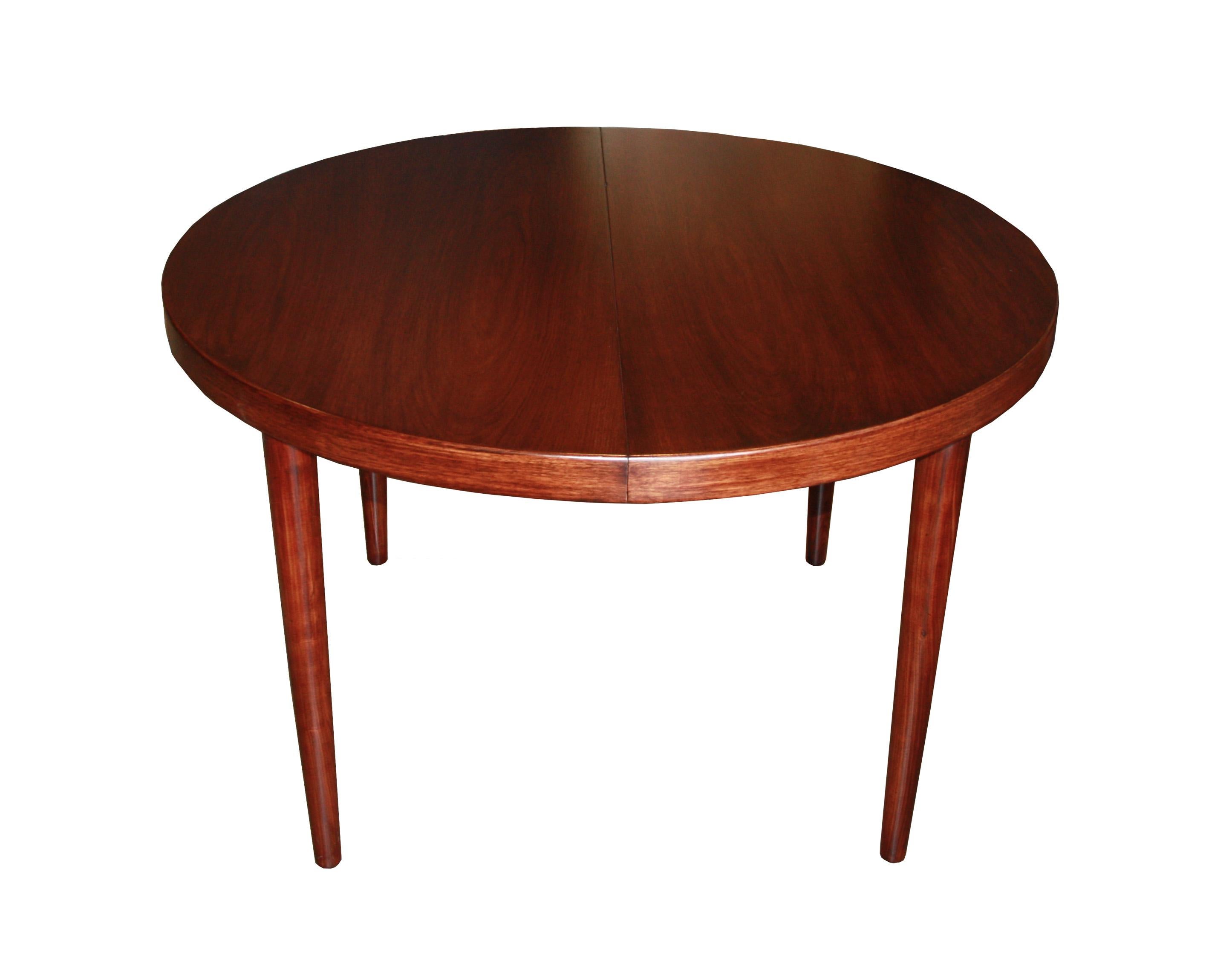 Beautiful, midcentury, round dining room table with a smooth, dark color and grain.