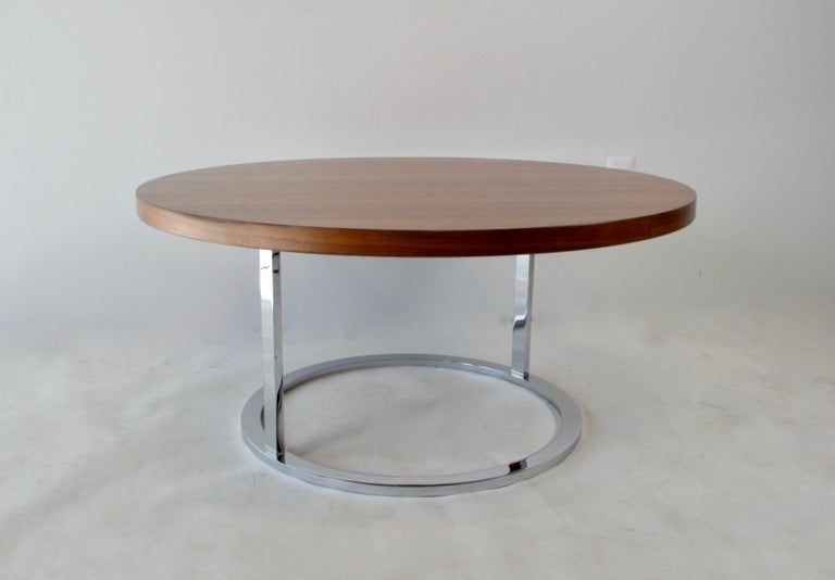 Milo Baughman style round coffee table in walnut with a chrome plated steel base. Professionally refinished walnut veneer top with solid steel base in excellent original condition. The grain of the wood is impressive and compliments the chrome.