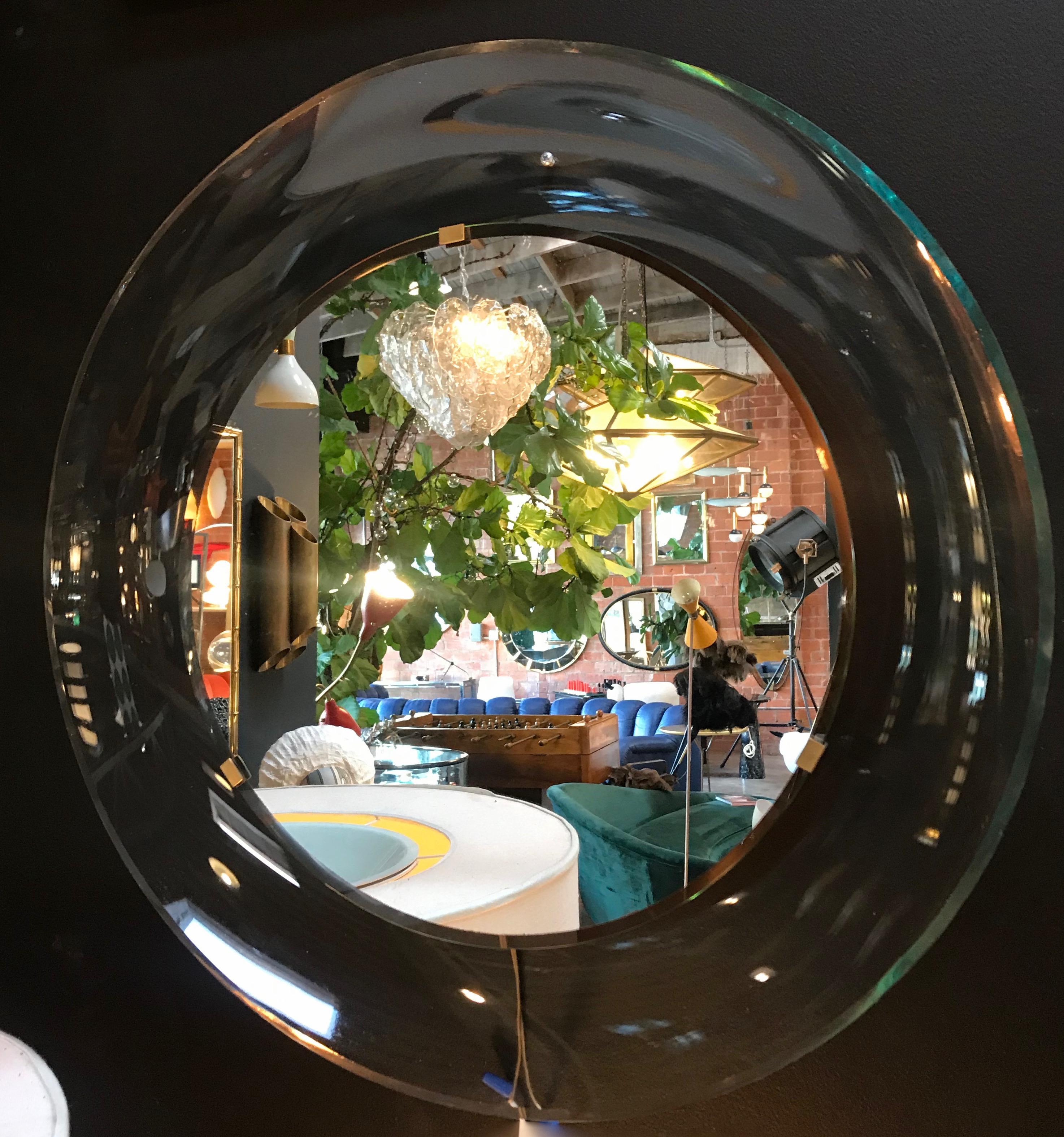 Fontana Arte pale transparent shallow concave dish mirror designed by Max Ingrand.
A round wall mirror by Max Ingrand for Fontana Arte, Italy. This model '1669' mirror from the 1960s has beveled glass.