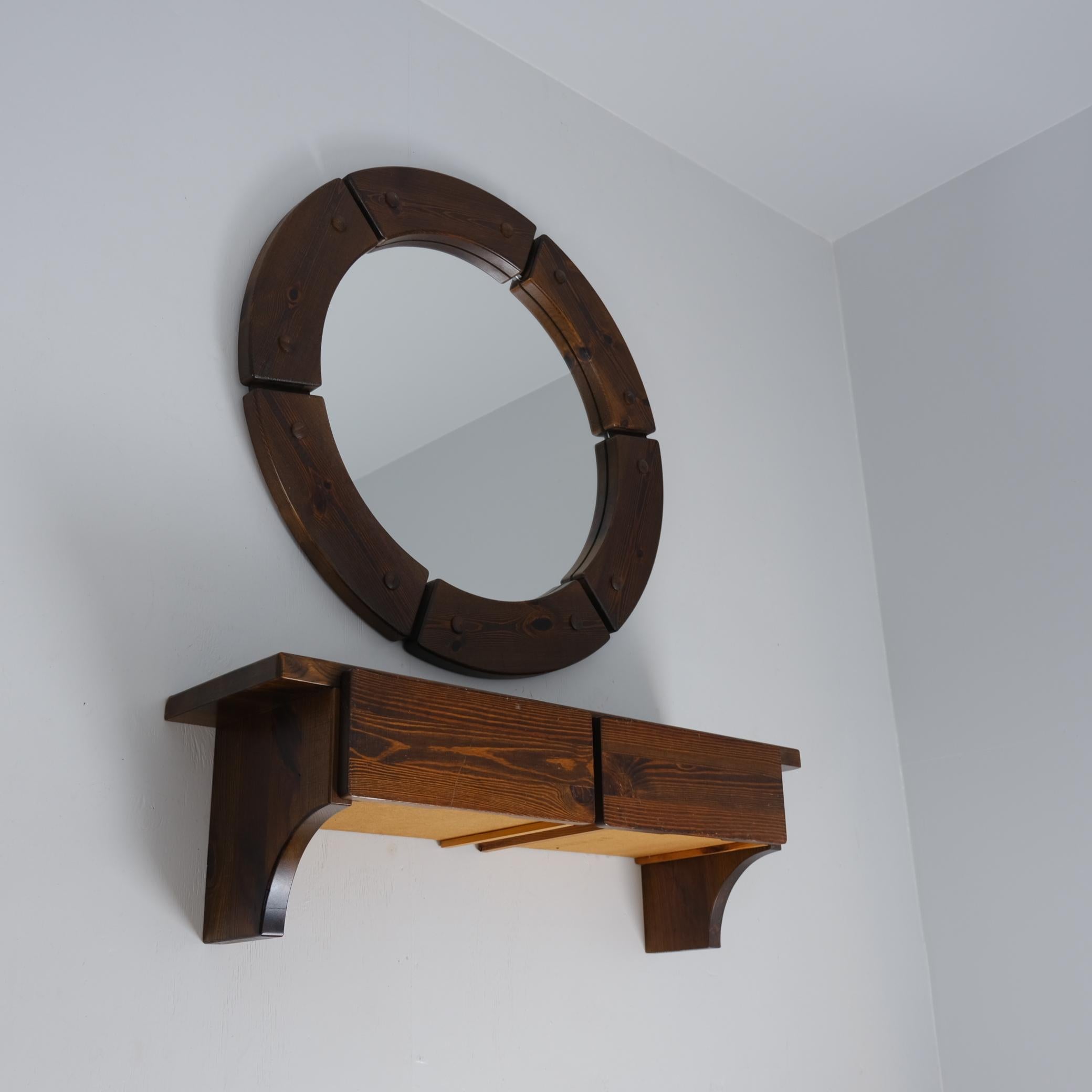 Una bellissima consolle in pino scuro composta da uno specchio rotondo e da una mensola sospesa a due cassetti. Il set ha un'aria un po' brutale, ma è abbastanza tranquillo e si adatta perfettamente a interni moderni ed eclettici, oltre che a quelli