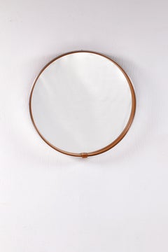 Round mirror covered with leather and chrome, made in France in the 1970s.