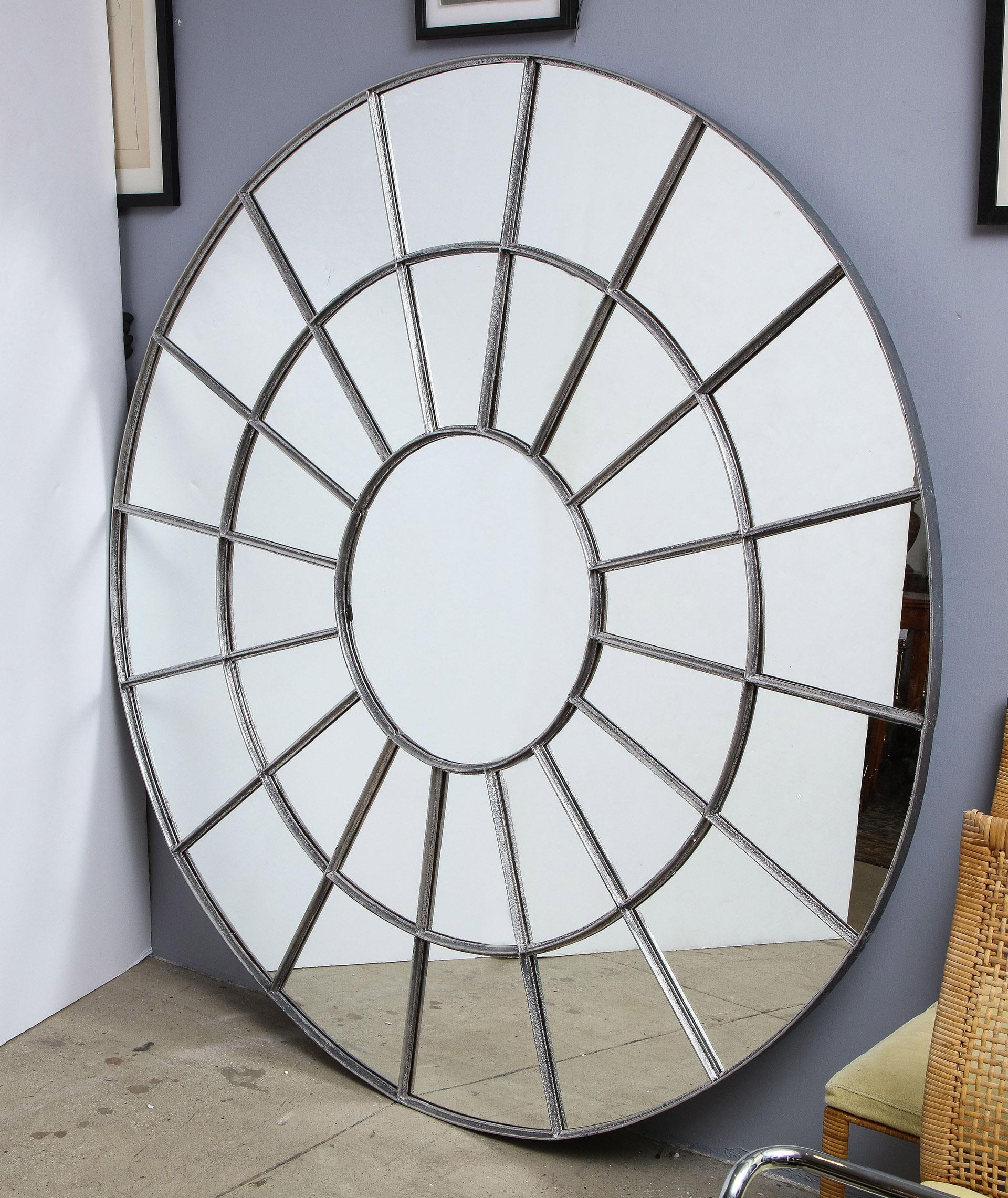 Monumental round gilt cast iron mirror

The silver gilt iron frame in a segmented design framing individual panels of mirror.