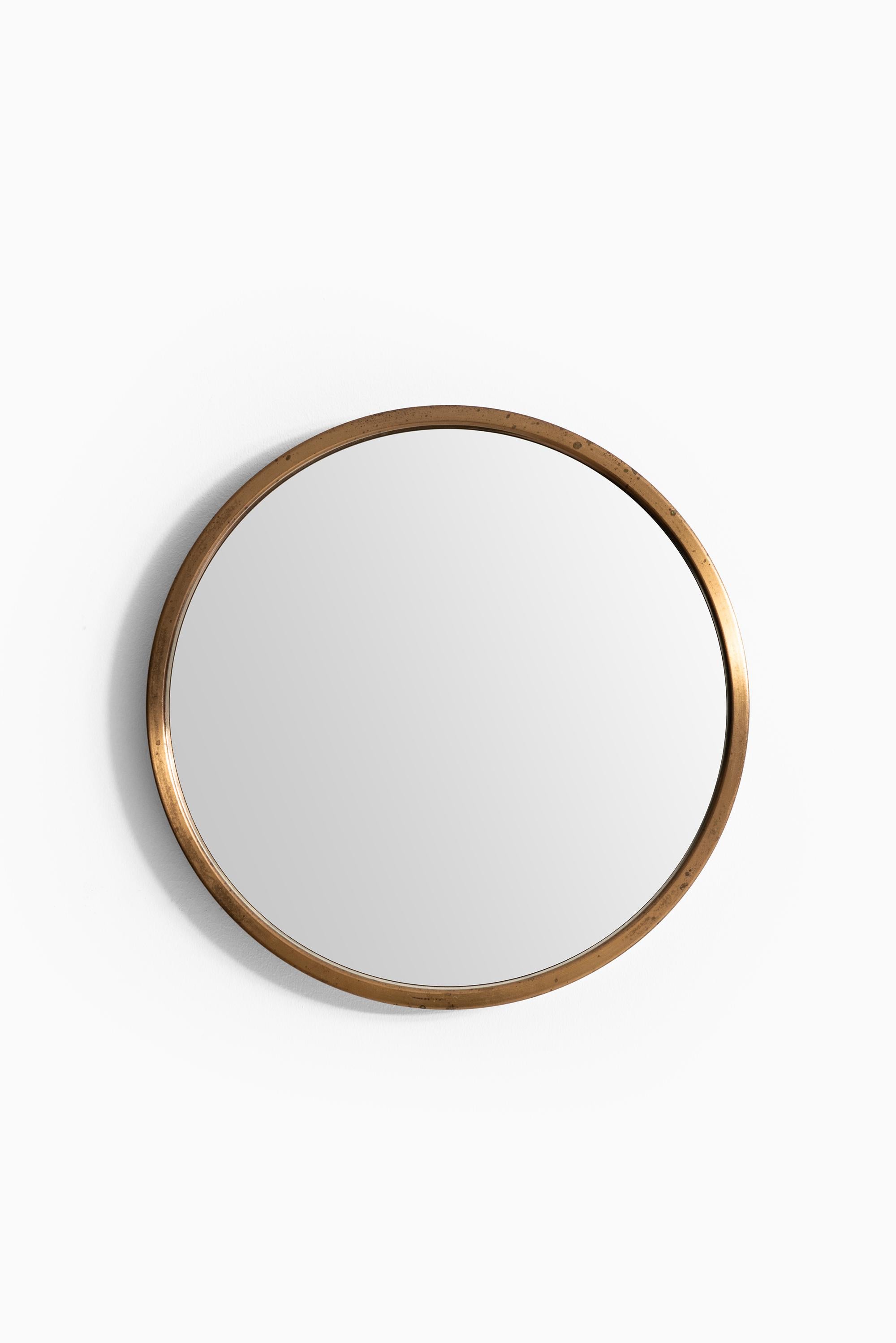 Round mirror in brass model nr 131. Produced by Glasmäster in Markaryd, Sweden.