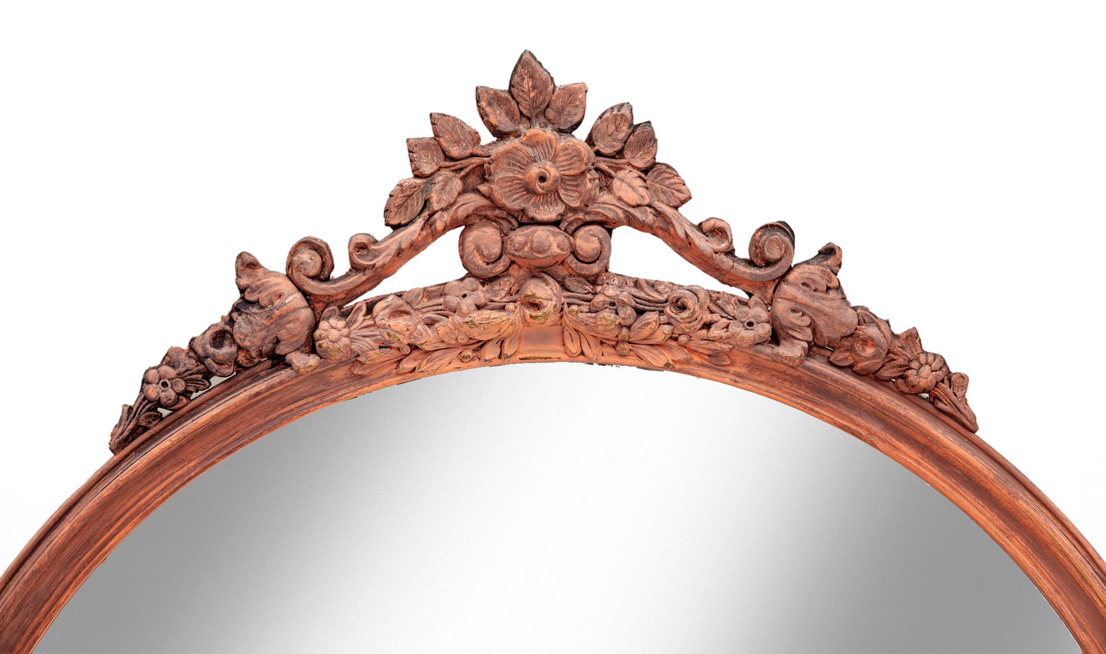 Crested round mirror, late art deo with original gold paint washed with a coral matte glaze. Frame is decorated with leafy scrolls, the crest is topped with a flower surrounded with a cluster of leaves.
30