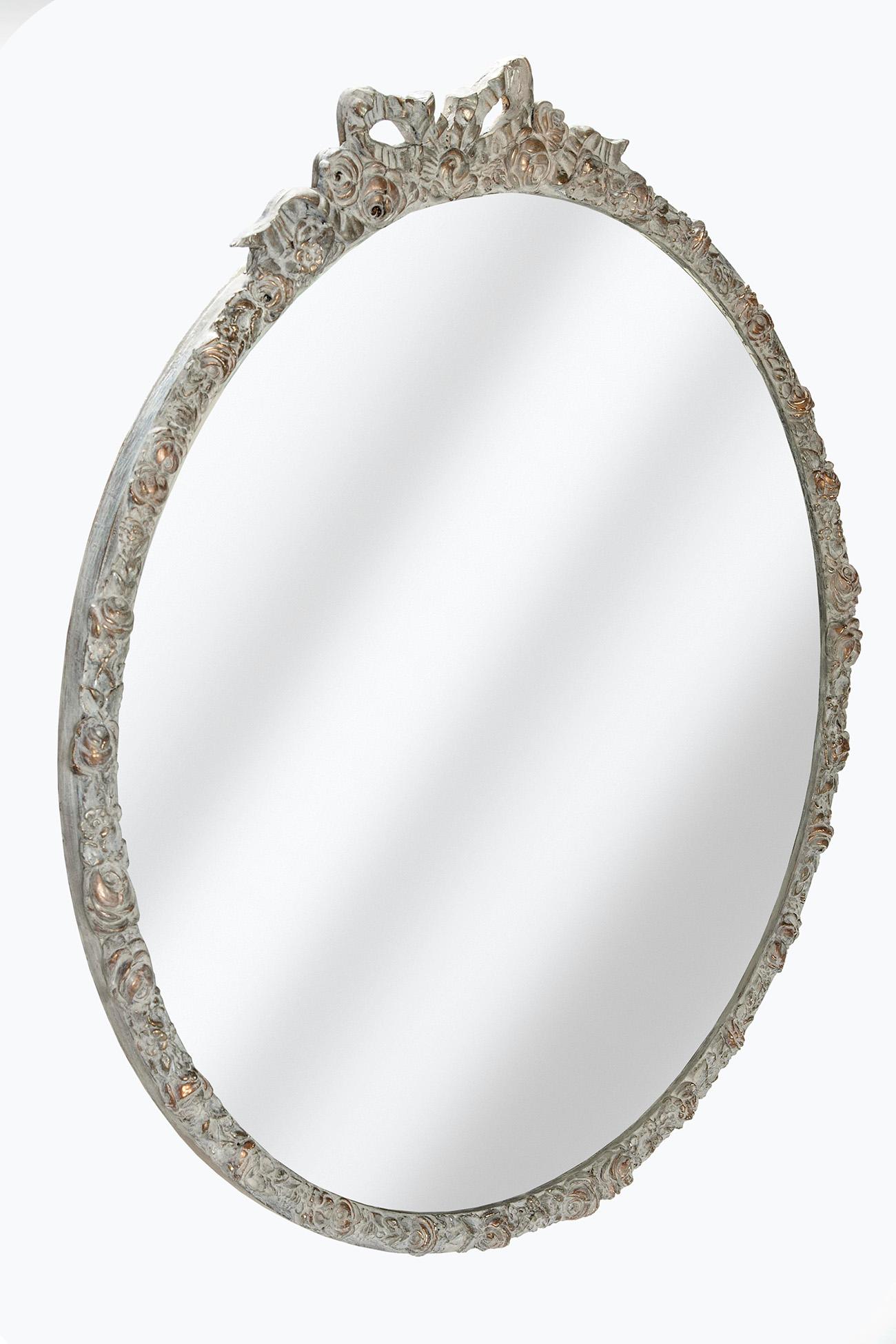 Restored late deco round mirror with ribbons &, roses, topped with a decorative little bow. Hand painted in shades of gold & topped in a French limed finish. The gold tones visible beneath the finish.