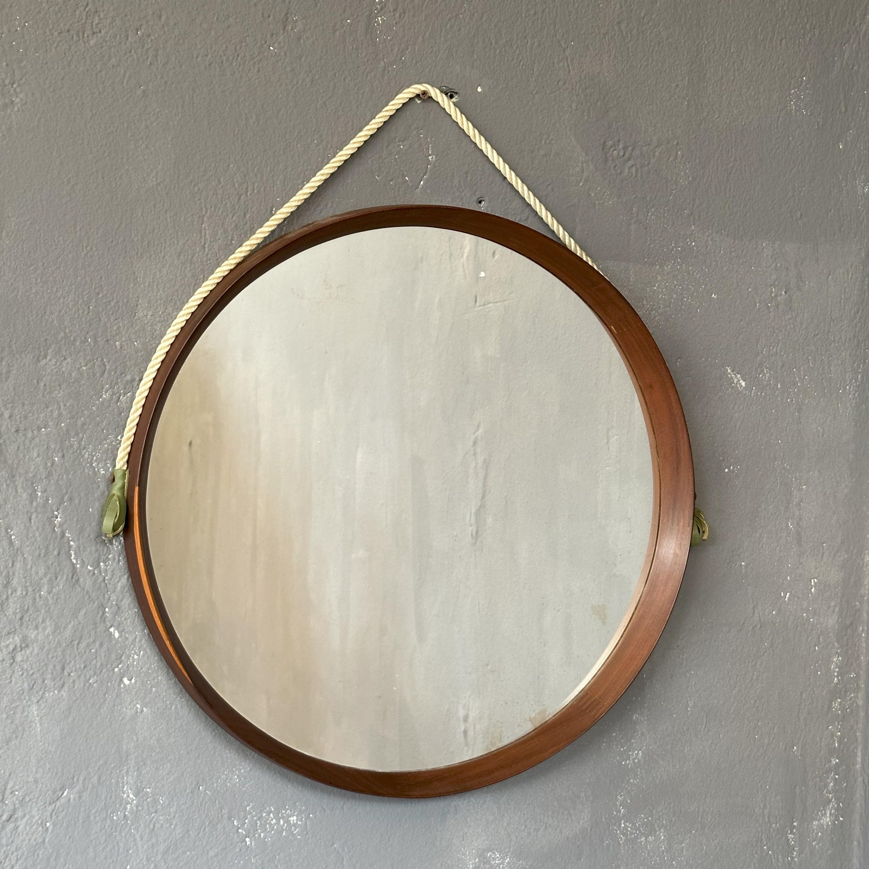 Miroir rond avec cadre en teck, années 1960, fabrication italienne, avec corde de suspension
Le miroir a un diamètre de 51cm, avec la corde il a une hauteur totale de 60cm.
Sur toute la circonférence, un cadre en teck avec de beaux détails en bois