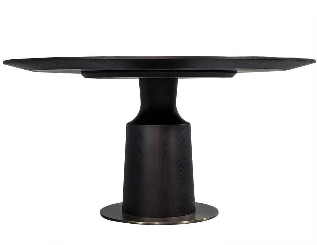 Round modern solid oak dining table with brass accents. Encompassing minimalism, eclecticism, and a blend of modern and transitional reference. With its graceful curves and sculptural physique, makes quite the impression. Ideal for intimate dining