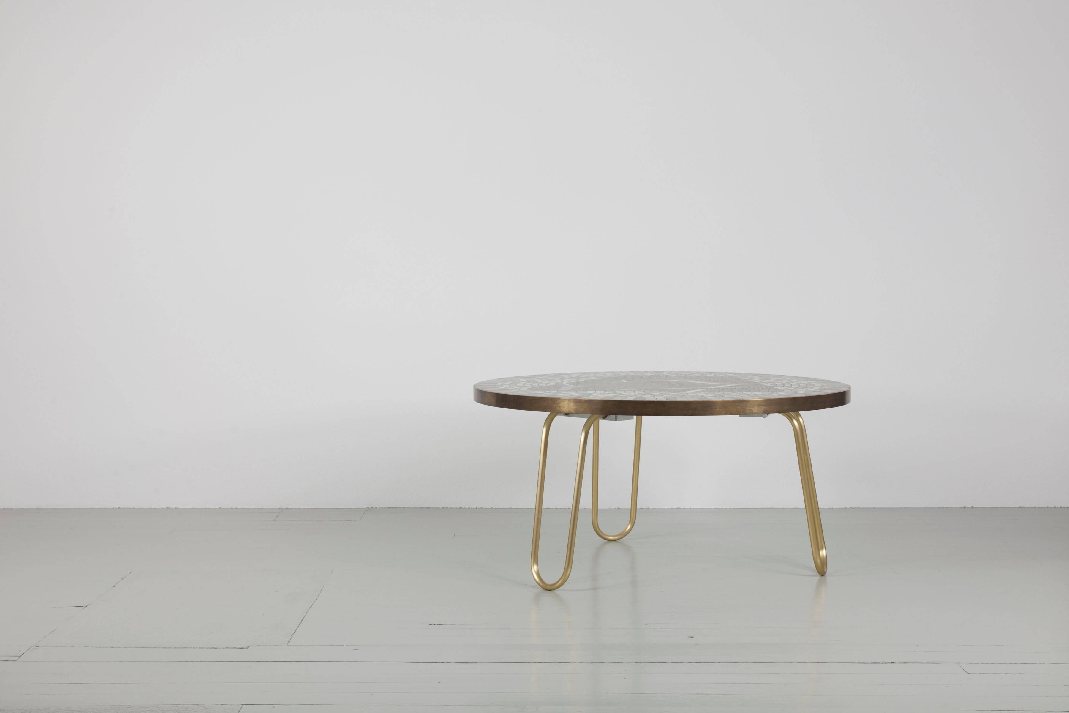 This mosaic table was designed in Germany in the 1950s by Berthold Müller. The round table top is designed with a seagull motif made of mosaic stones and edged with brass. This piece of furniture is an exceptional one-off. The round table legs are