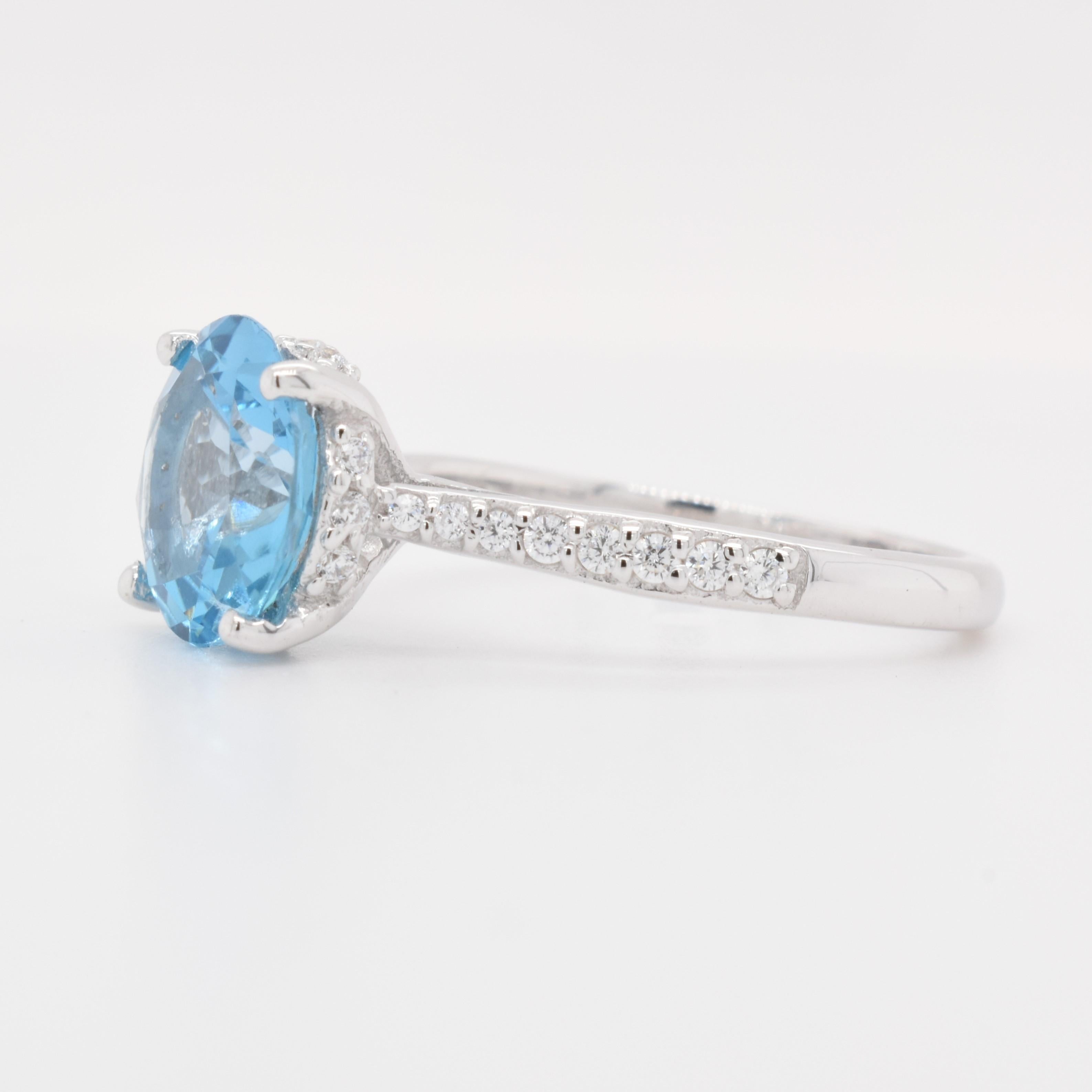 Round Shape Swiss Blue Topaz Gemstone beautifully crafted with CZ in a Ring. A fiery Blue color December Birthstone. For a special occasion like Engagement or Proposal or may be as a gift for a special person.

Primary Stone Size - 9x9mm