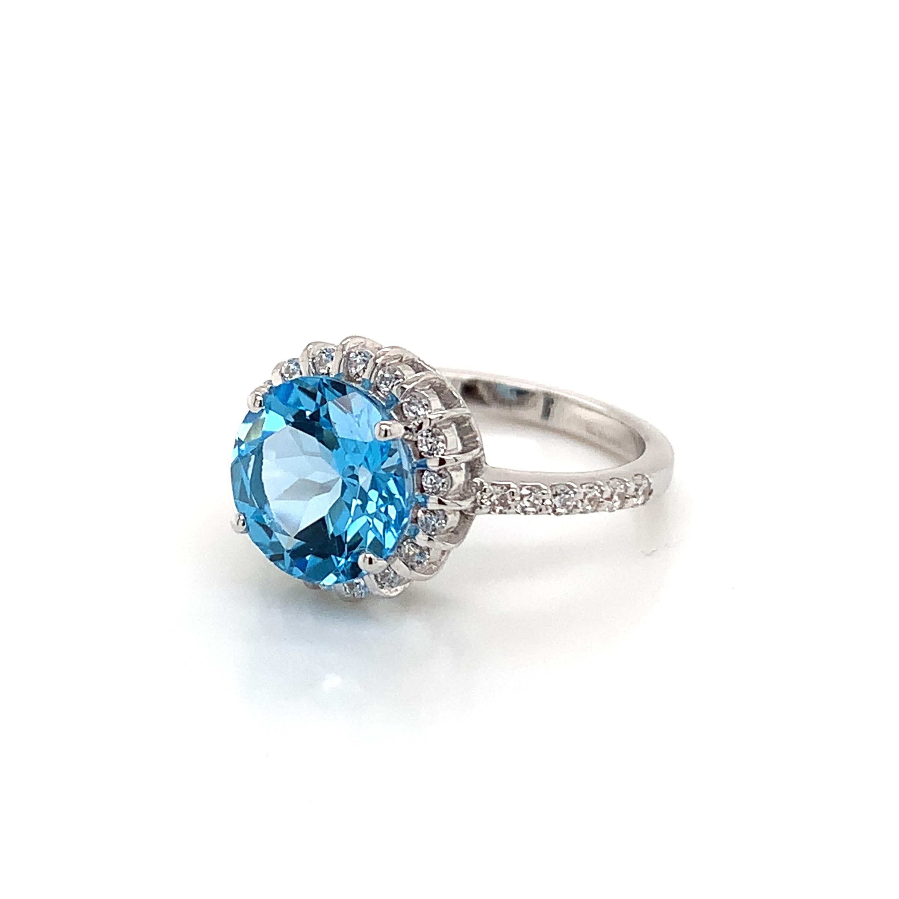 Round Shape Swiss Blue Topaz Gemstone beautifully crafted with CZ in a Ring. A fiery Blue color December Birthstone. For a special occasion like Engagement or Proposal or may be as a gift for a special person.

Primary Stone Size - 9x9mm