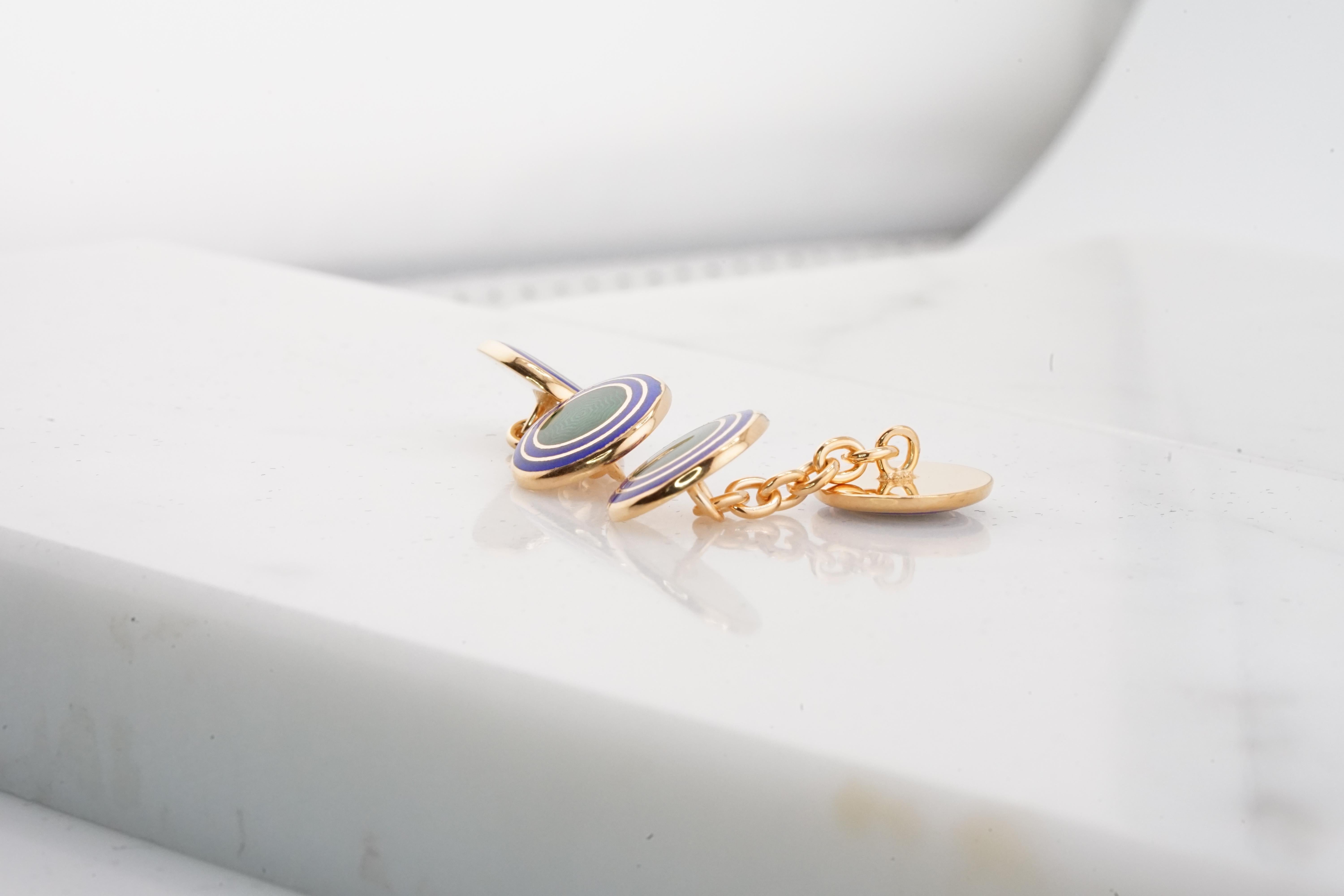 Exquisite pair of Italian-made cufflinks, meticulously crafted from gold-plated sterling silver. These cufflinks boast a unique round shape. The central surface features lustrous green enamel, encircled by two concentric rings of vibrant blue