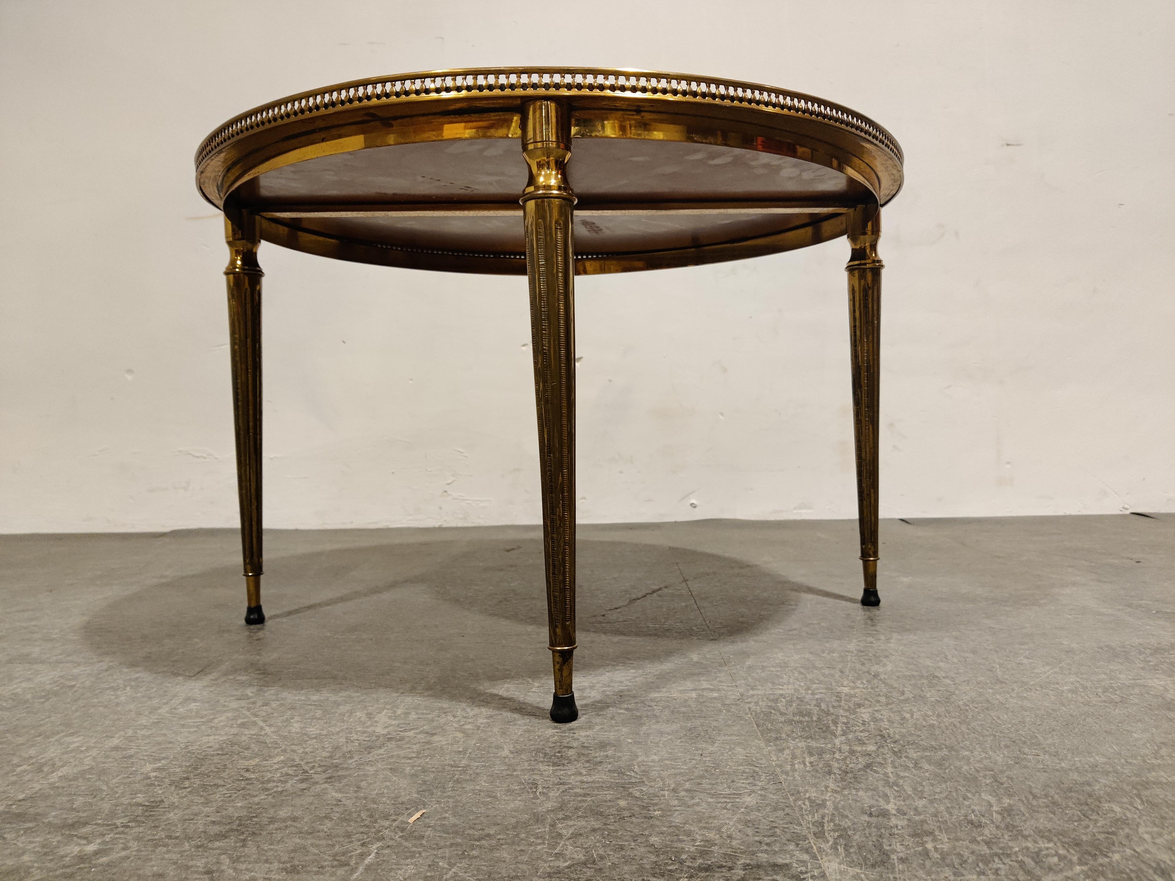 Mid century neoclassical coffee table in gilt metal with a nicely worn glass top.

Well crafted piece.

Good condition

1960s - Italy

Dimensions:

Height: 46cm/18.11”
Diameter: 70cm/27.55”.

 