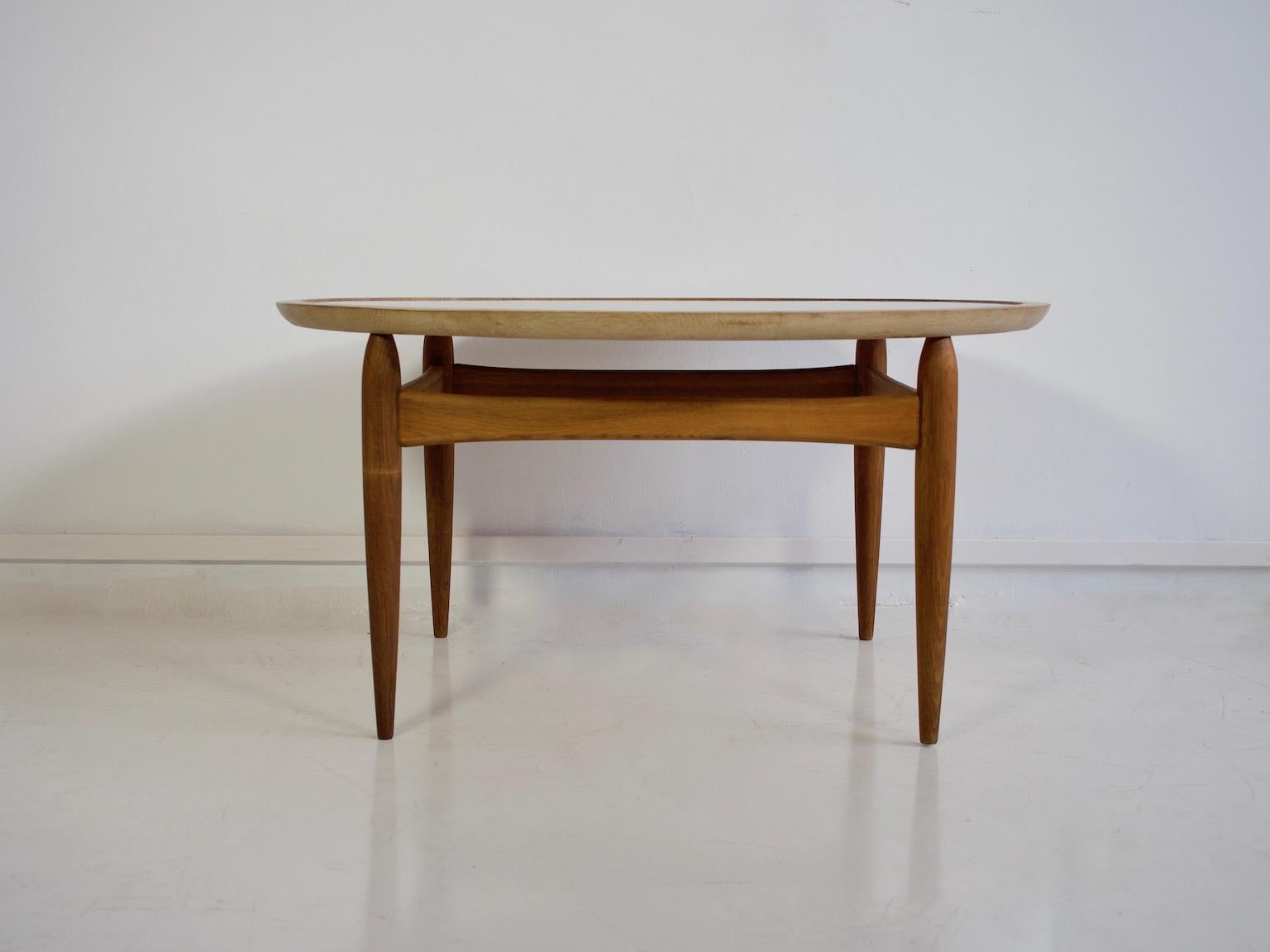 Round coffee table attributed to Ejvind A. Johansson, manufactured by Ludvig Pontoppidan, circa 1950s-1960s. Circular reversible tabletop with inlaid black Formica on one side and oak on the other side. Solid oiled oak frame with tapered legs.