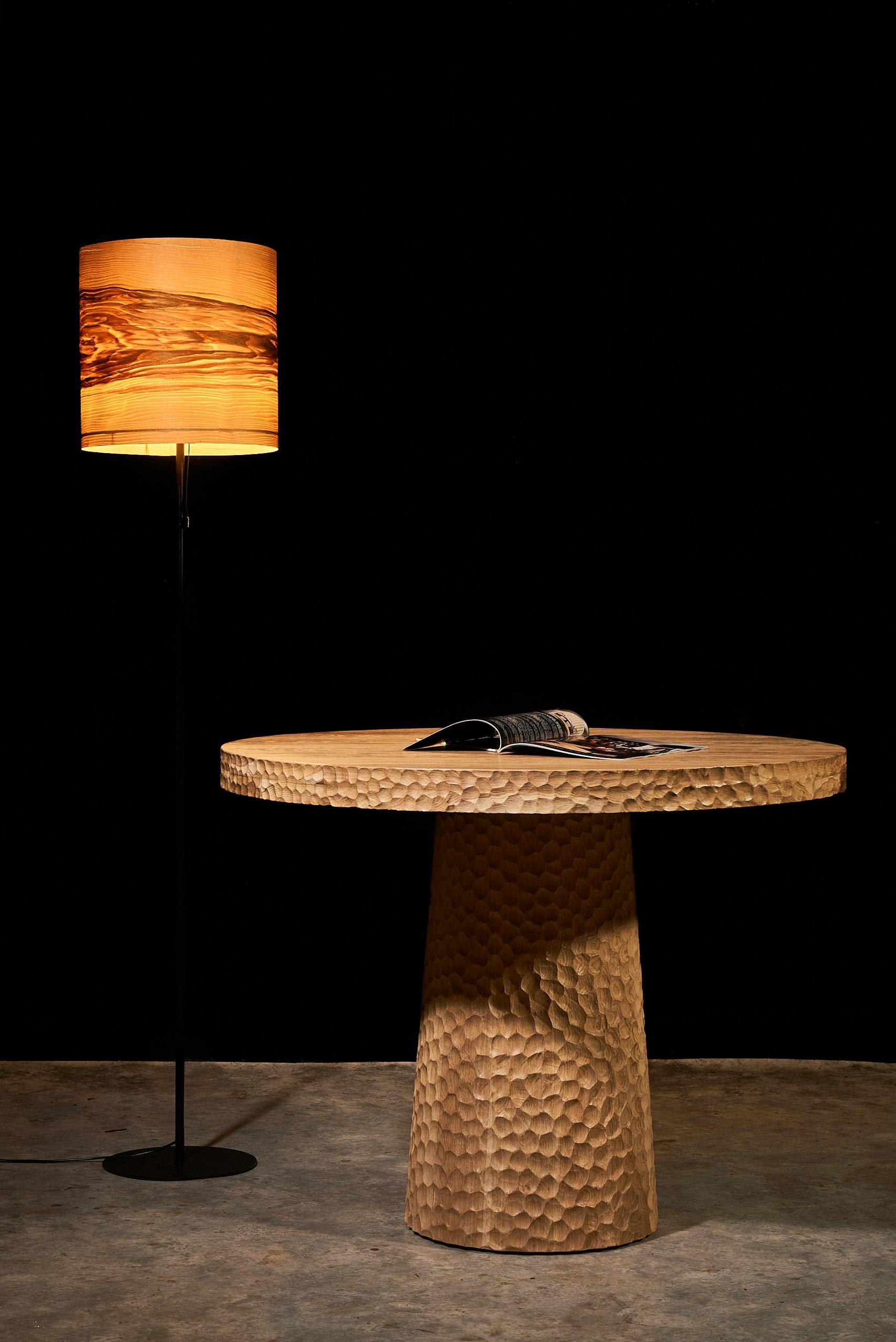 Crafted from solid oak with a hand-carved surface and sculptural cone base, this round dining table balances raw texture and geometric purity. Designed by Sergio Vulpe, it merges brutalist strength with organic softness.

This 100 cm (39.4 in) round