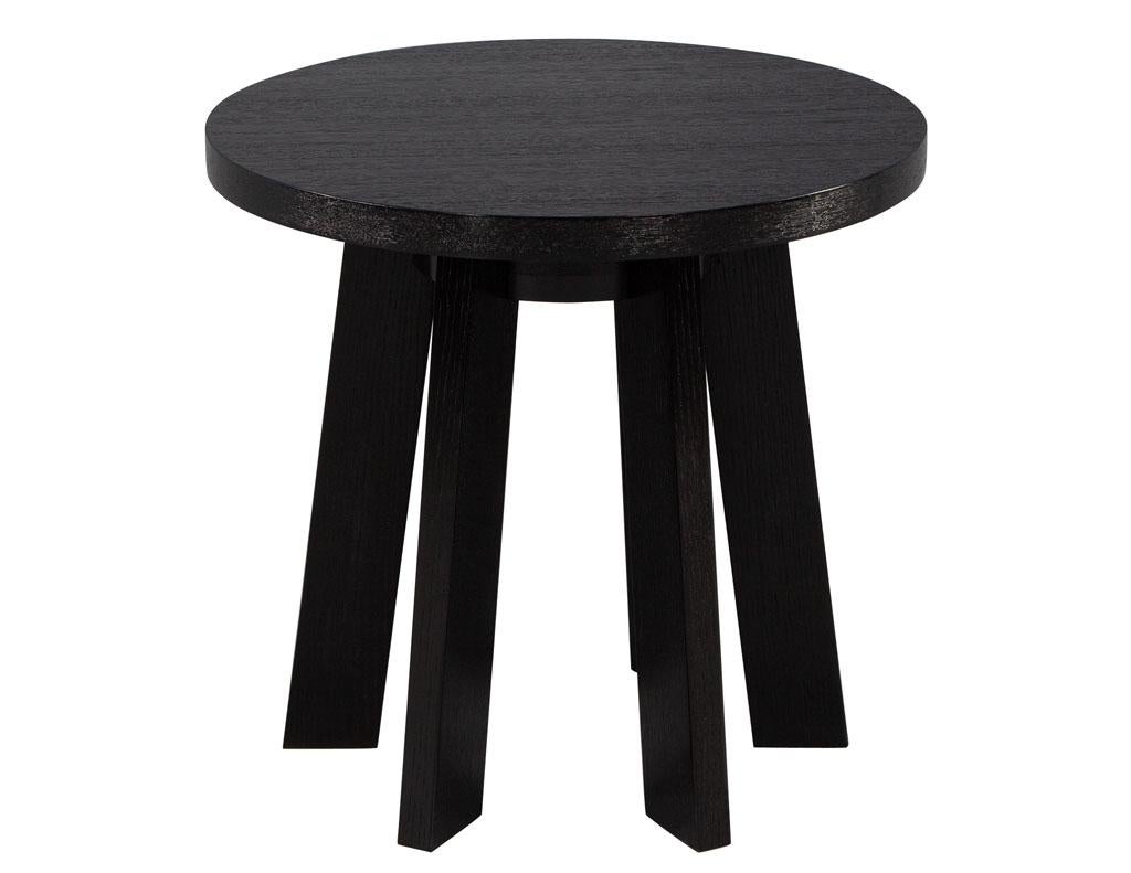 Round Oak Side Table in Black Cerused Finish. Simplistic modern styling with a rustic inspiration. Featuring oak woods with cerused finish accenting the beautiful natural wood grains. Large round top with 6 clean cut angled legs. The perfect accent