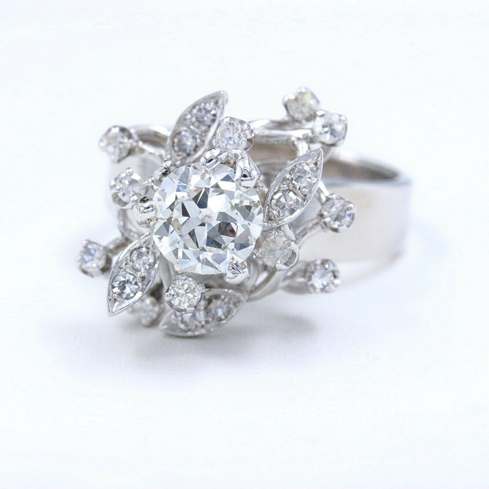 Round Diamond Flower Cocktail Ring

Metal:  18k White Gold
Size:  6 - sizable
Width:  5 MM - 3 MM Band
Height:  14 MM  Width:  13 MM
Total Carat Weight:  1.12 tcw
Center Diamond Shape:  Round Old European Cut 0.80 cts  I color, SI1 clarity
Accent