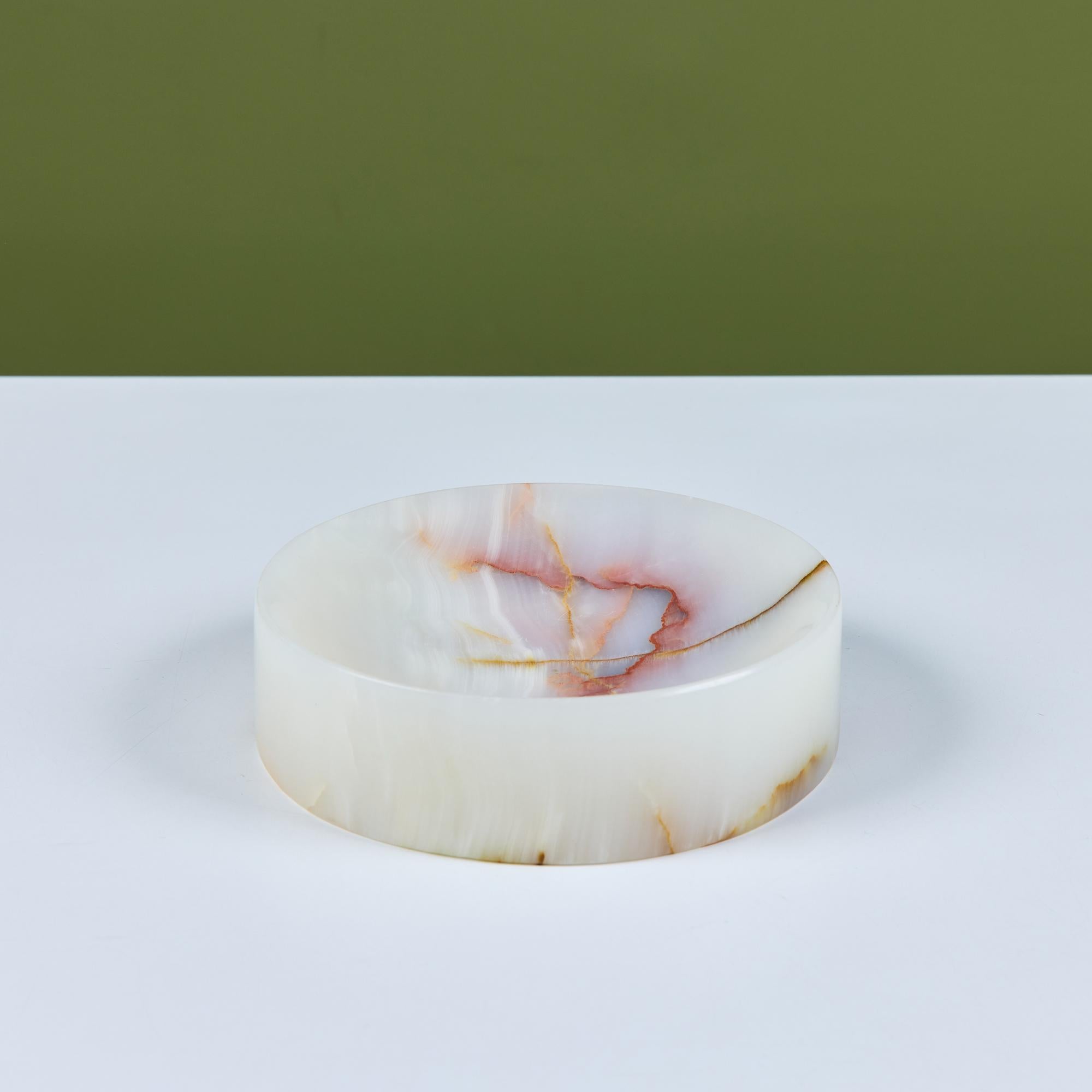 Polished onyx ashtray features an all over cream color with brown and red veining throughout and a thick edge. The round vessel has a deep curved well perfect for trinkets, ash or even keys, the perfect catchall.

Dimensions
7