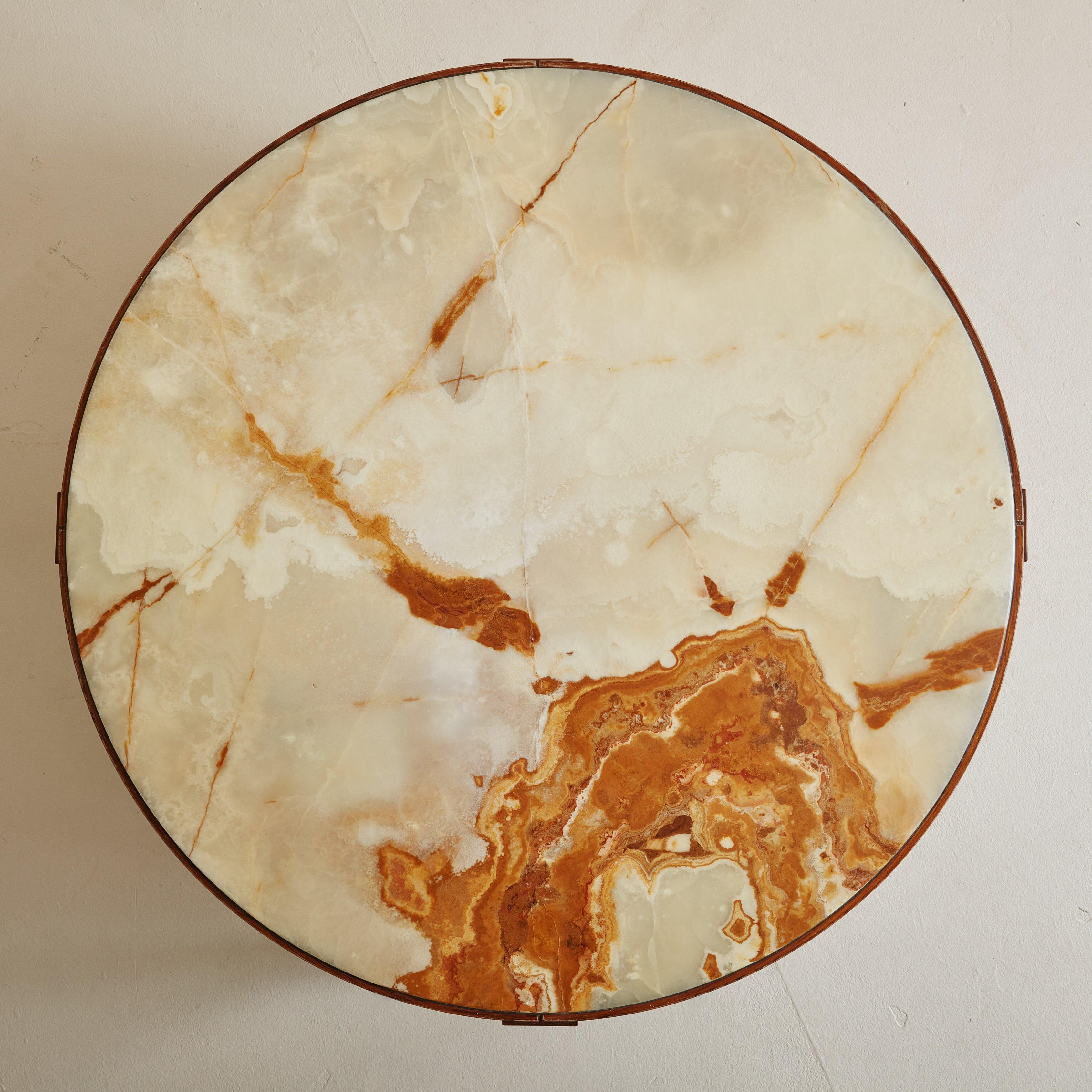 A 1960s Danish Modern coffee table attributed to Trioh. This coffee table features a smooth, round onyx table top with stunning veining in a range of cream, warm ochre, and burnt orange hues. The natural stone is set within a solid wood frame