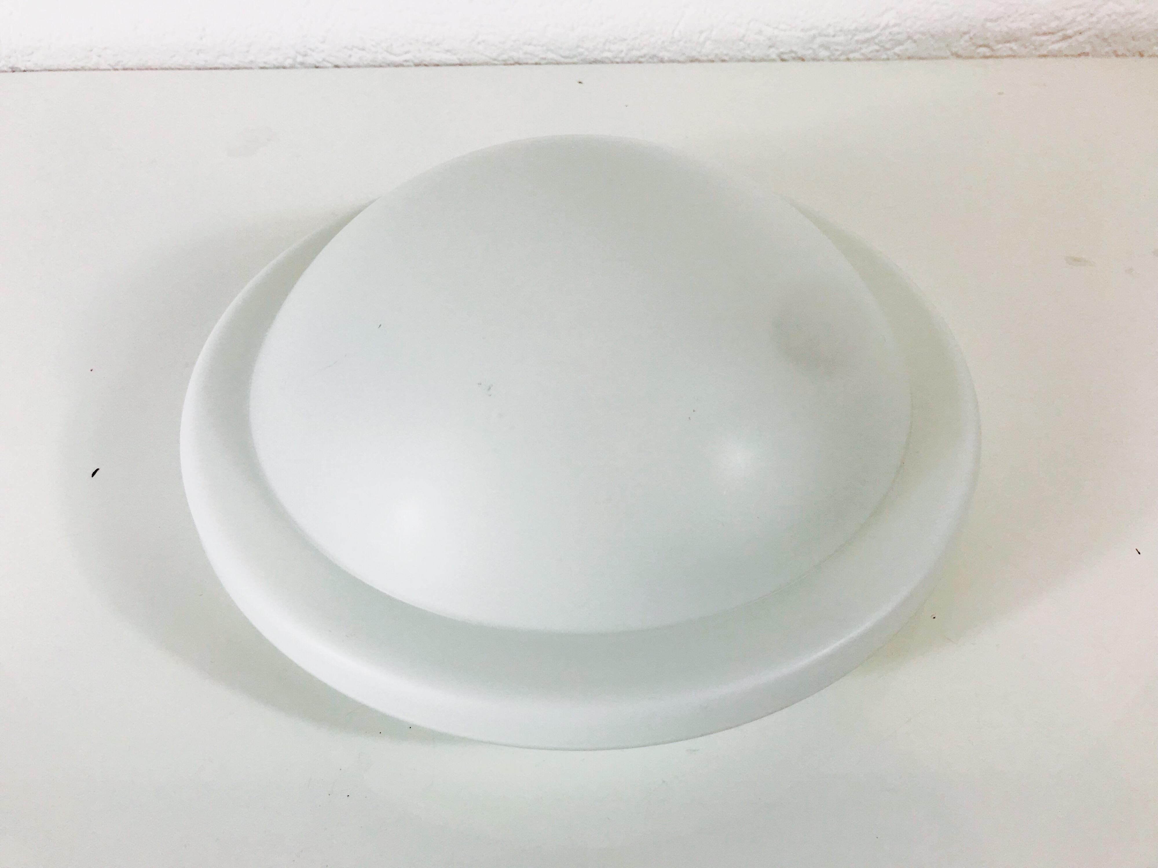 A round flush mount by Peill and Putzler made in Germany in the 1960s. It is fascinating with its beautiful white opaline glass. The lamp has a Space Age design.


 