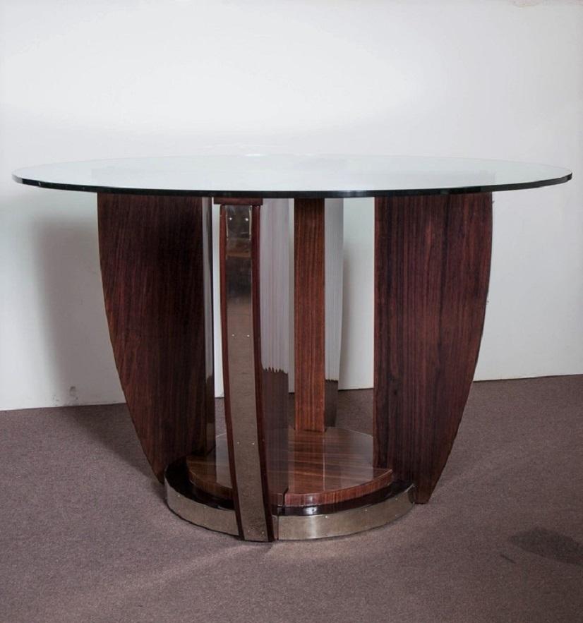 A highly elegant circular shaped French Moderne center table of purist form crafted in beautifully grained palisander with stepped base holding four arc shaped winged sides displaying nickeled bronze mounts and banding.
Attributed to: Louis Sognot