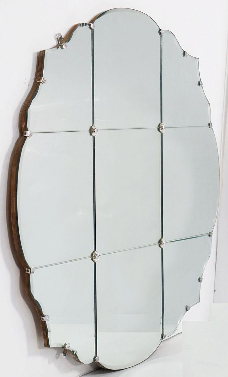 Un grand miroir cartouche rond ou circulaire en verre biseauté d'Angleterre (diamètre 37 3/4 pouces) avec un bord festonné ou serpentin et un intérieur lambrissé sur un support en bois.