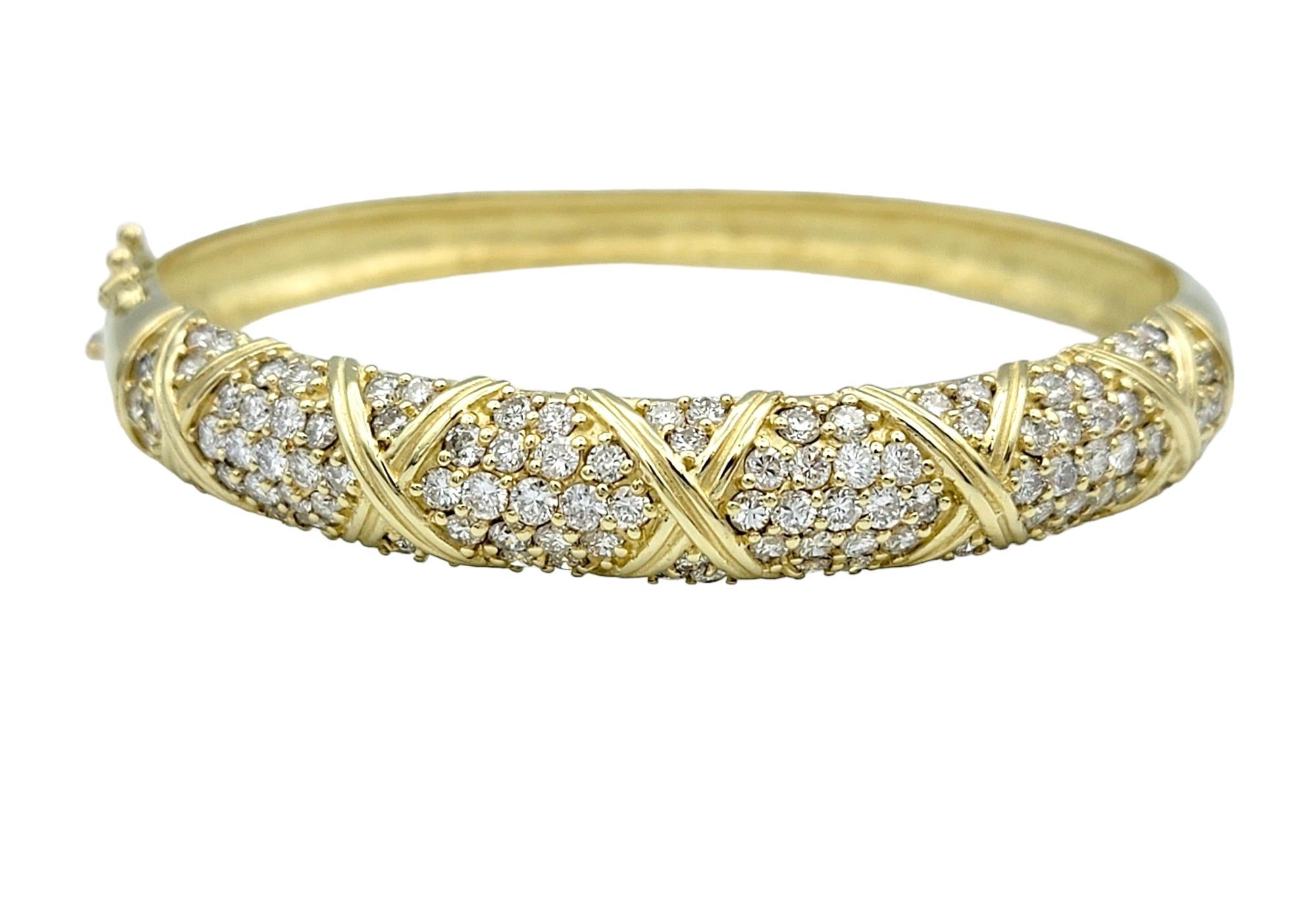 Radiating opulence and sophistication, this diamond bracelet, exquisitely set in lustrous 14 karat yellow gold, epitomizes timeless elegance and luxury. Adorning the bangle bracelet are dazzling diamonds meticulously encrusted throughout, their